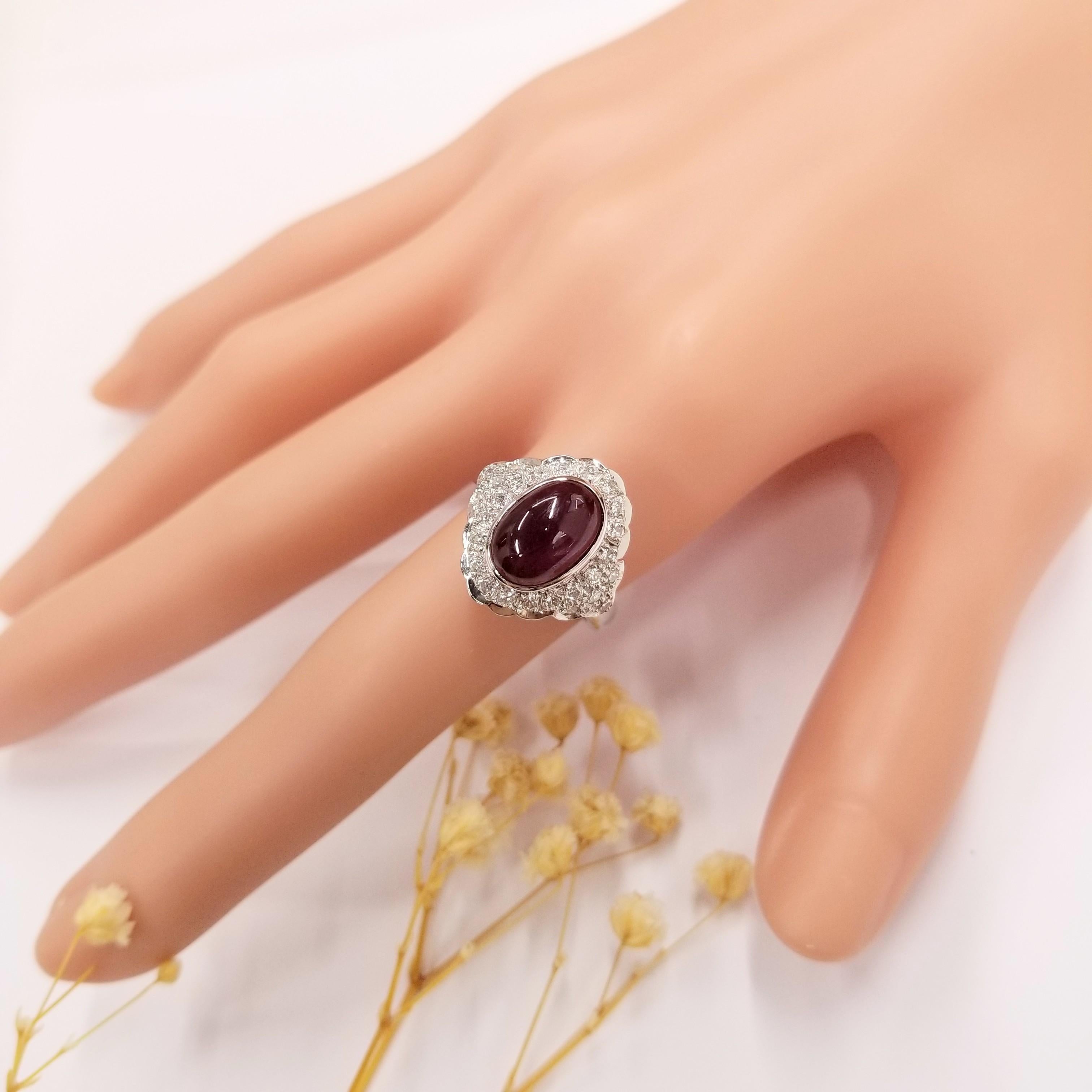 Immerse yourself in the enchanting world of vintage glamour and sophistication with this IGI Certified 3.30 Carat Cabochon Oval Ruby Ring. This exquisite piece showcases a magnificent deep purplish red ruby, certified by IGI, in a cabochon oval