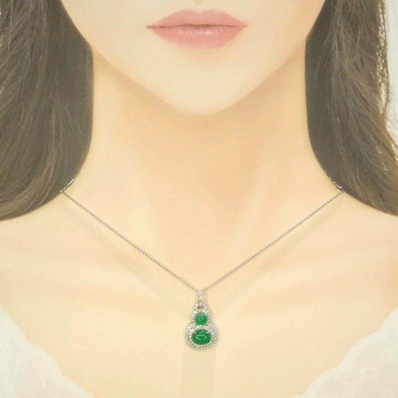 Découvrez une pièce vraiment exceptionnelle qui marie couleurs vibrantes et élégance intemporelle dans ce superbe pendentif, conçu dans la forme auspicieuse du wulu (葫蘆). Cette silhouette emblématique, formée par deux magnifiques émeraudes ovales en