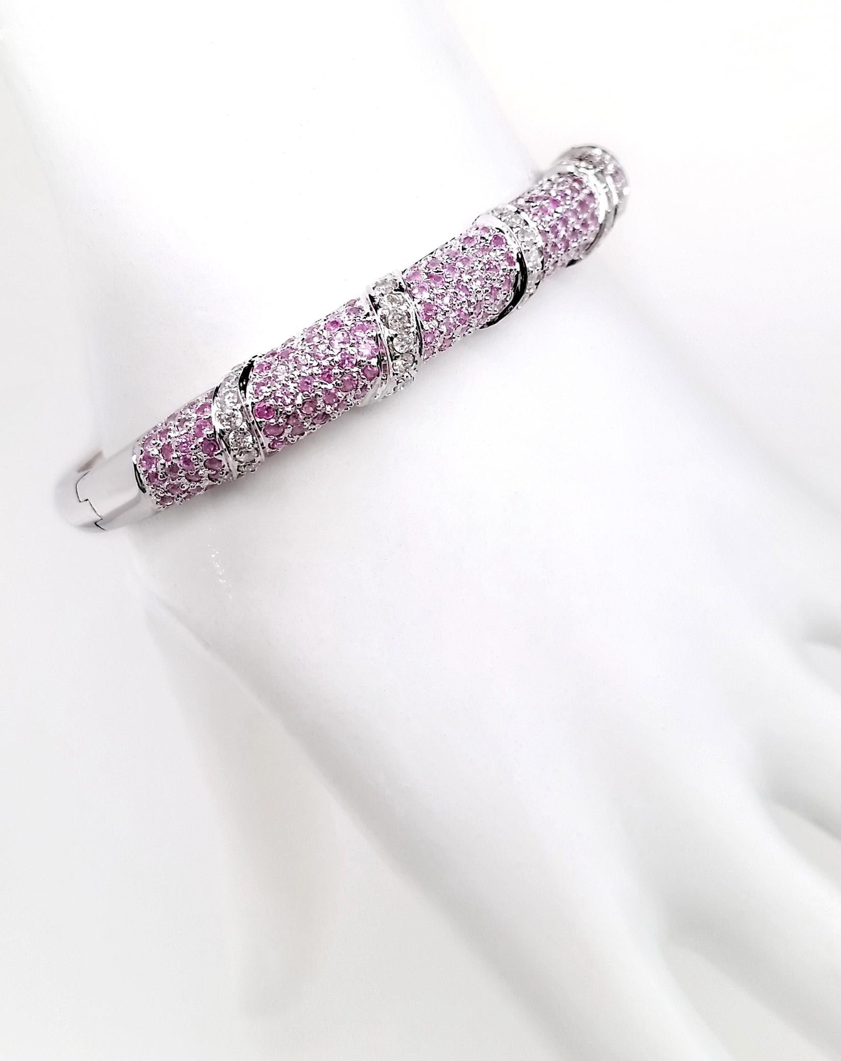 Elegant 18K white gold bangle featuring 3.65 carats of natural pink sapphires and 0.95 carats of brilliant diamonds. This luxurious masterpiece showcases 202 pink sapphires in stunning purplish pink to intense pink shades, beautifully accented by 40