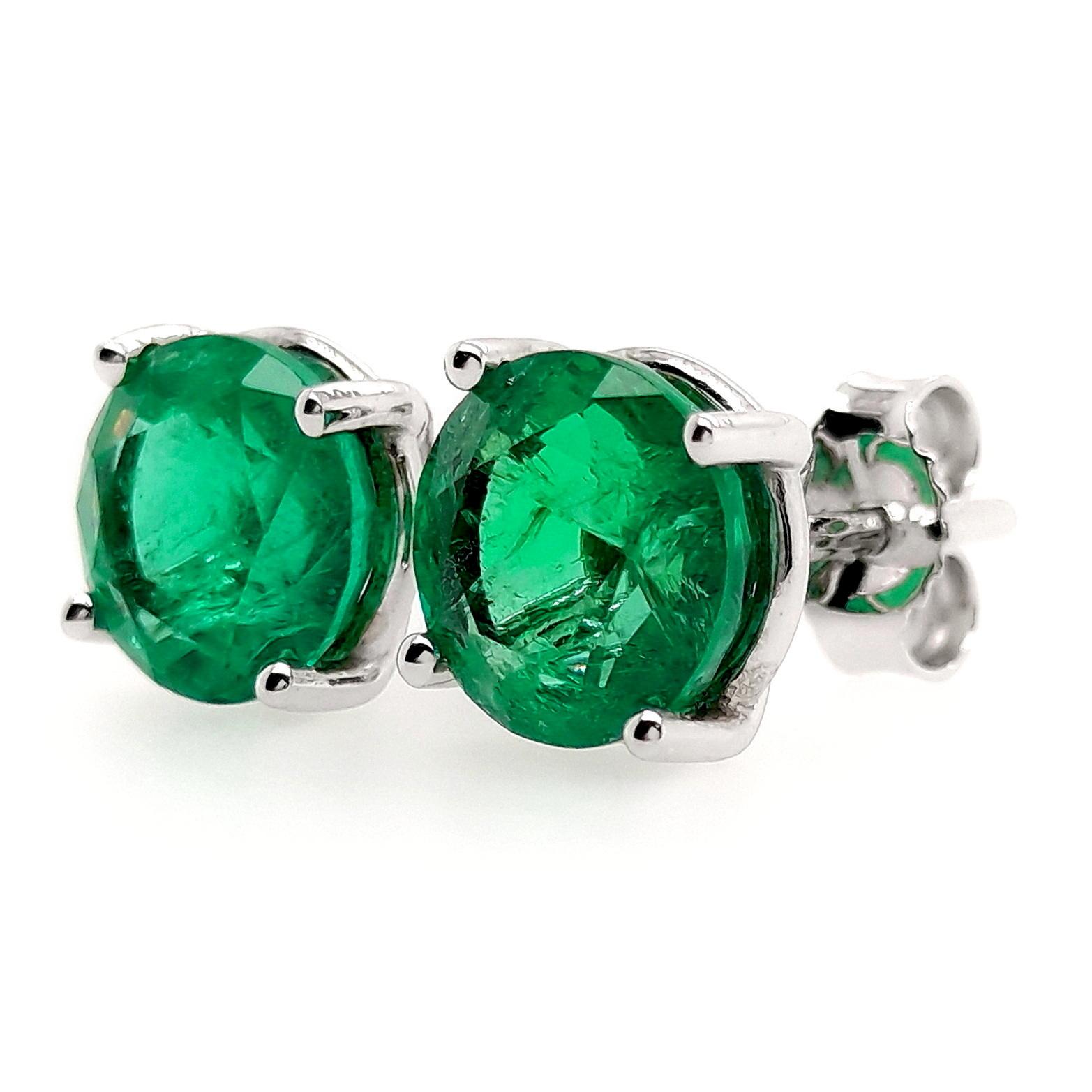 Indulge in the enchanting allure of 4.14 carats intense-green round emeralds, gracefully showcased in a 18K white gold setting. These earrings epitomize refined elegance, everlasting charm, and luxurious beauty, promising to elevate your style with