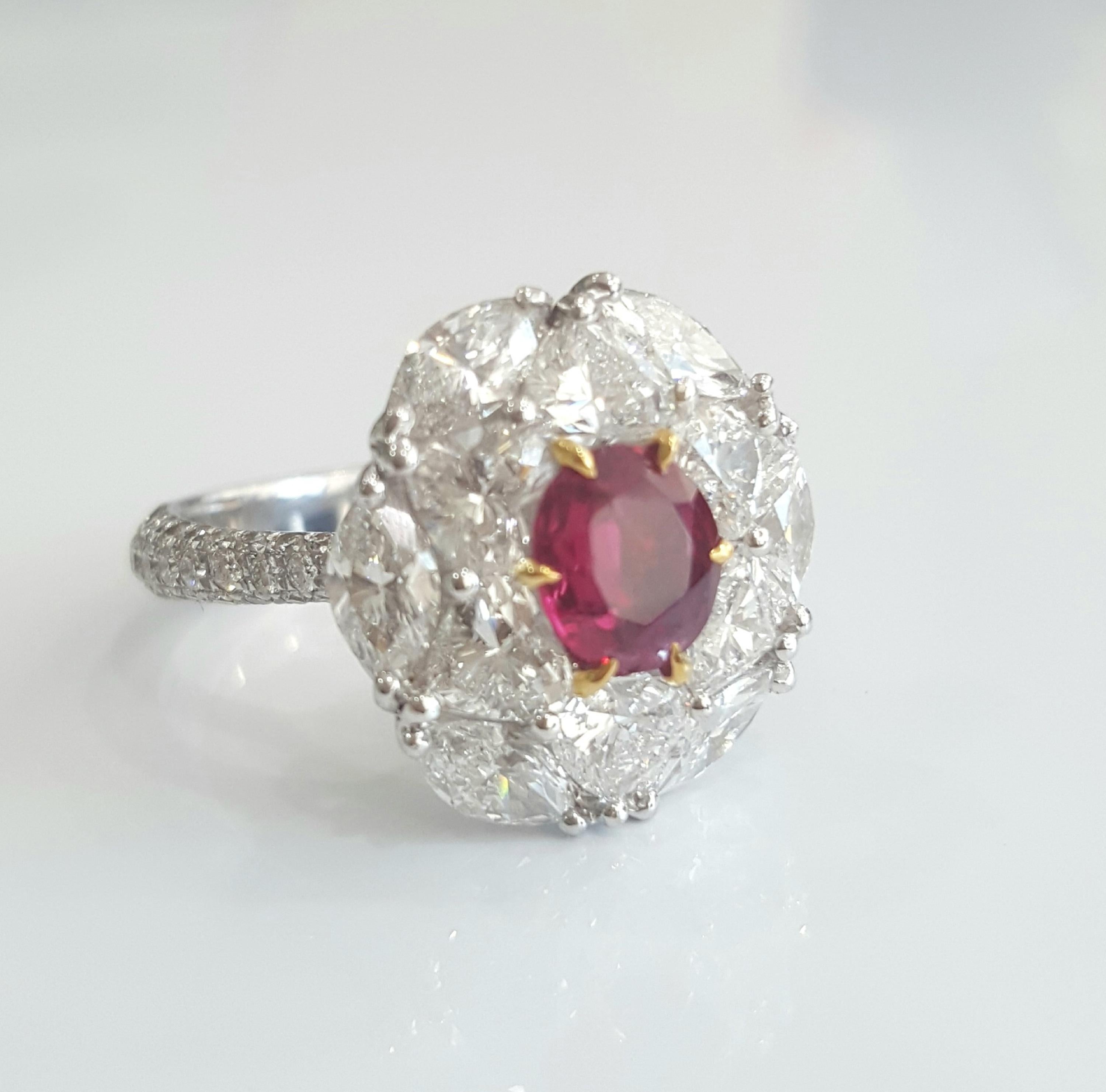 Dieser einzigartige, brillante und außergewöhnliche Ring wurde von Moguldiam Inc. entworfen und ist mit einem IGI-zertifizierten ovalen Rubin besetzt
keine Hitze mit einem Gewicht von 0,93 Karat, umgeben von wunderschön gefassten weißen Diamanten in