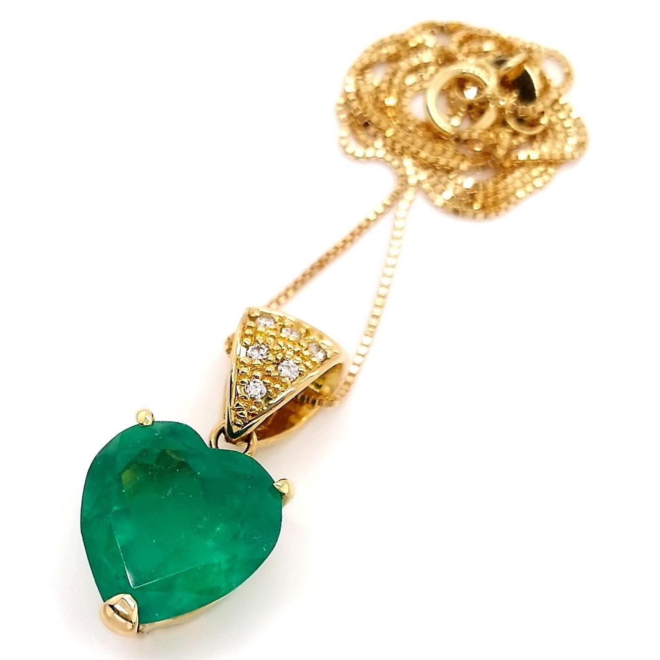 This splendid heart-shaped Colombian emerald pendant, from Top Crown Jewelry, has an intense bluish-green fine color quality and is adorned by natural round brilliant-cut diamonds suspended on a light decorated 18K yellow gold chain. 
The necklace