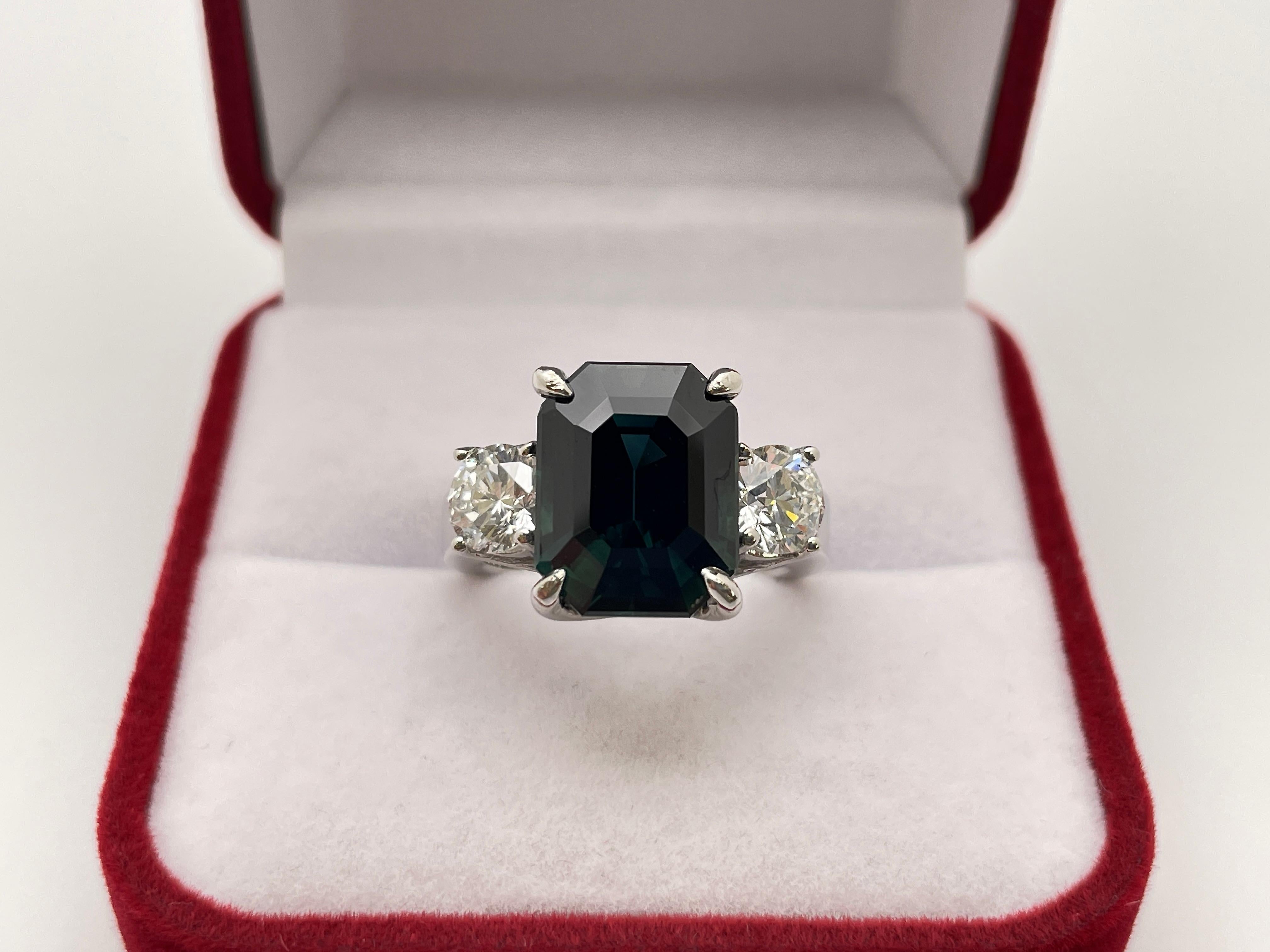 An extraordinary 14K white gold diamond and sapphire engagement ring, accompanied by an IGI certificate. Centered with a magnificent IGI-certified rectangular emerald deep green/blue natural corundum sapphire weighing 7.51 CT and measuring 12.42 x