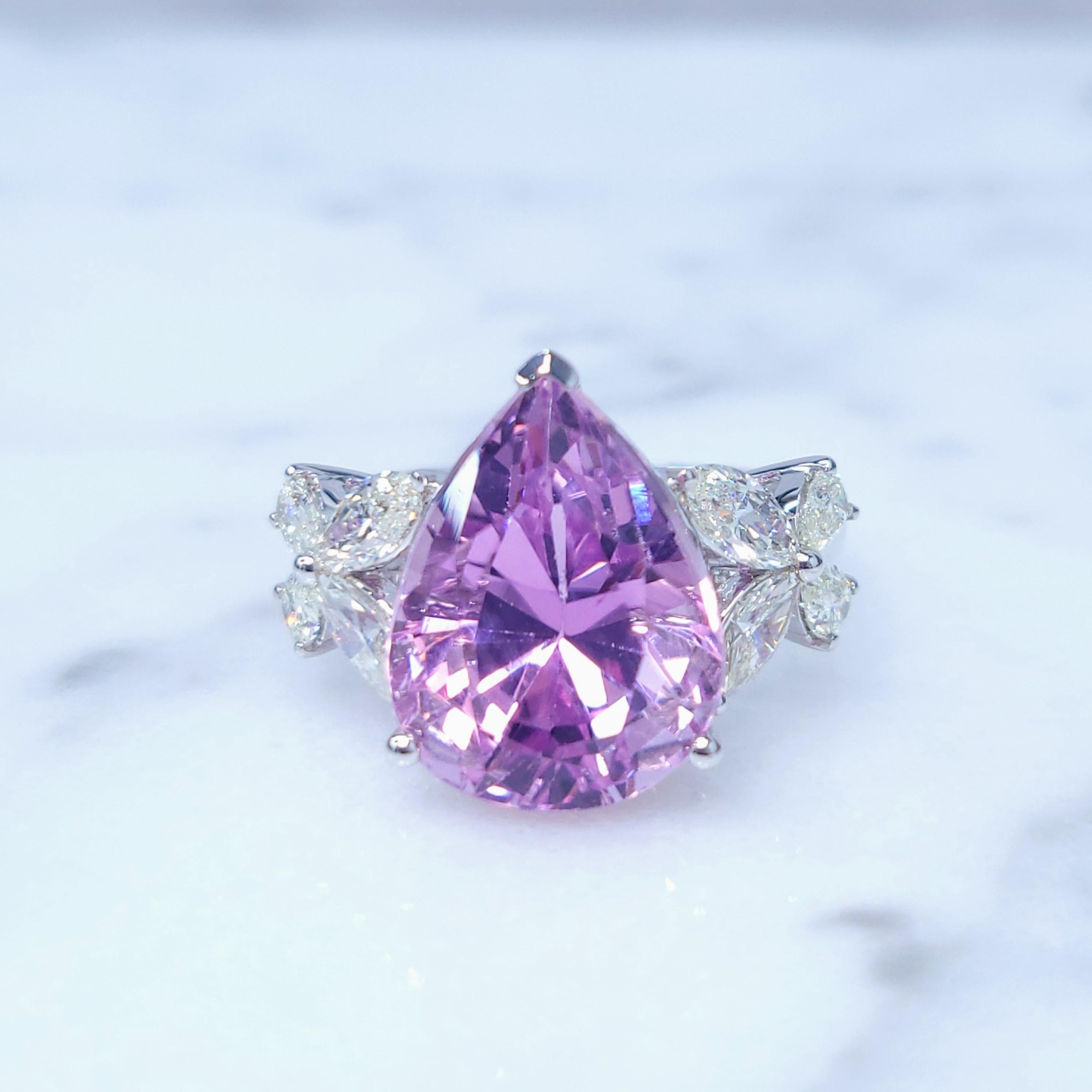 This exquisite ring features a stunning 7.90-carat pear-shaped Kunzite, a rare and beautiful gemstone known for its captivating purplish-pink color. The ring features a stunning pear-shaped pink sapphire as the centerpiece. The sapphire is set in a