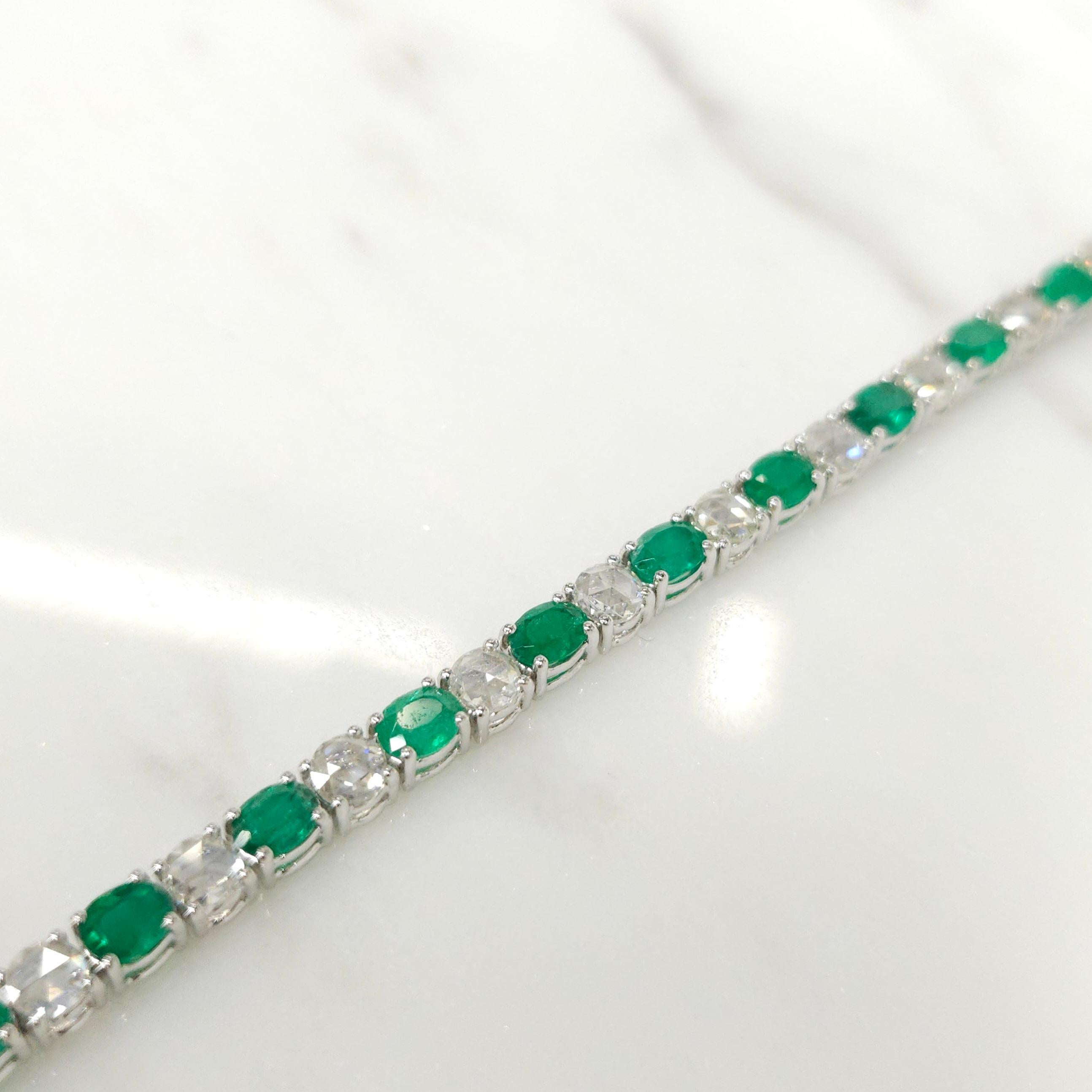 Introducing the exquisite 18K white gold tennis bracelet, adorned with alternating 3.76 Ct oval cut emeralds and 2.37 Ct round rose cut white diamonds. This stunning piece is not only a symbol of luxury but also a testament to the timeless beauty of
