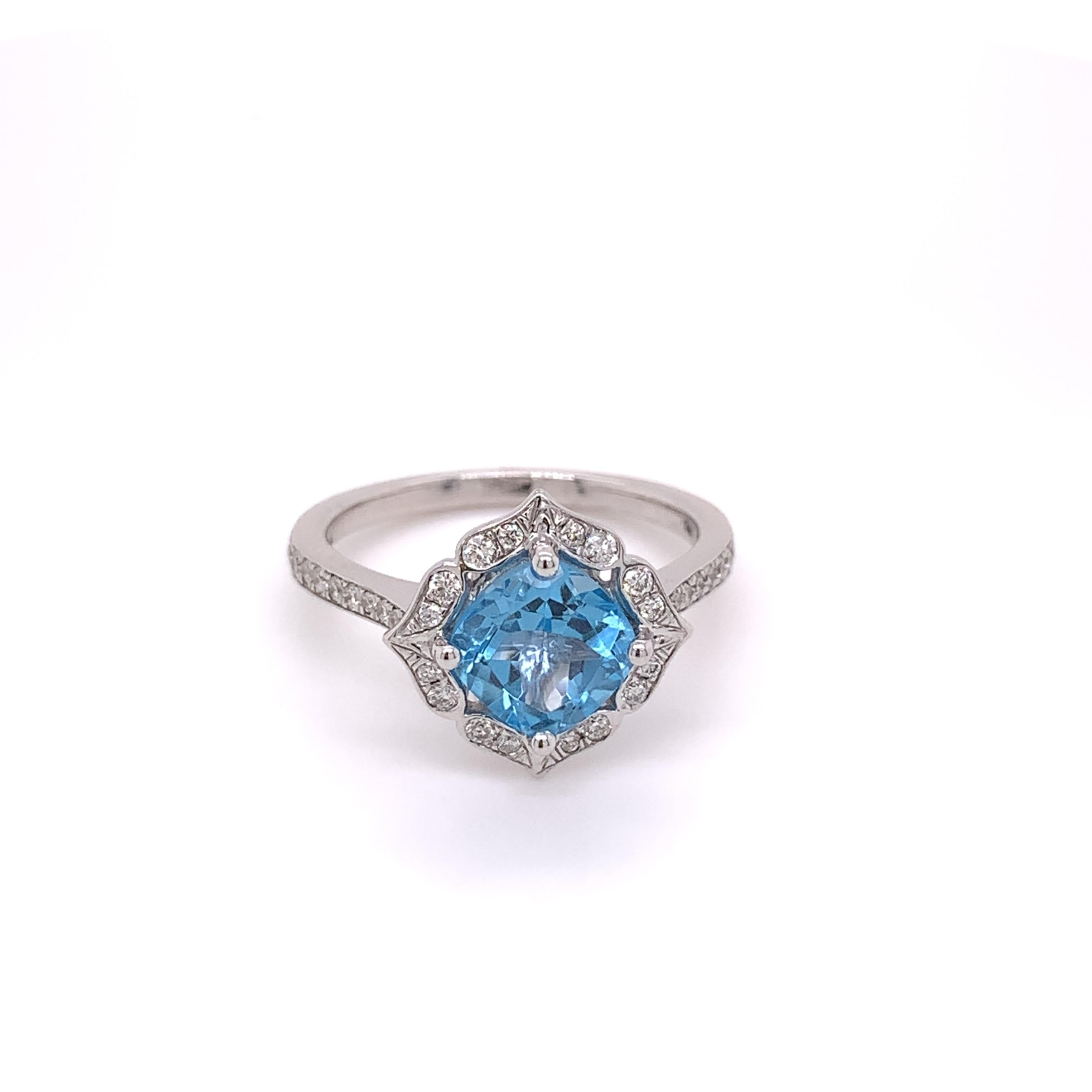 This ring weighs was crafted in 14 karat white gold. It has a natural 1.37 carat cushion cut blue topaz measuring 7.00 x 7.00 x 4.50mm. This ring also contains 36 natural round brilliant diamonds weighing approximately 0.27 carats (H-I color, and I1