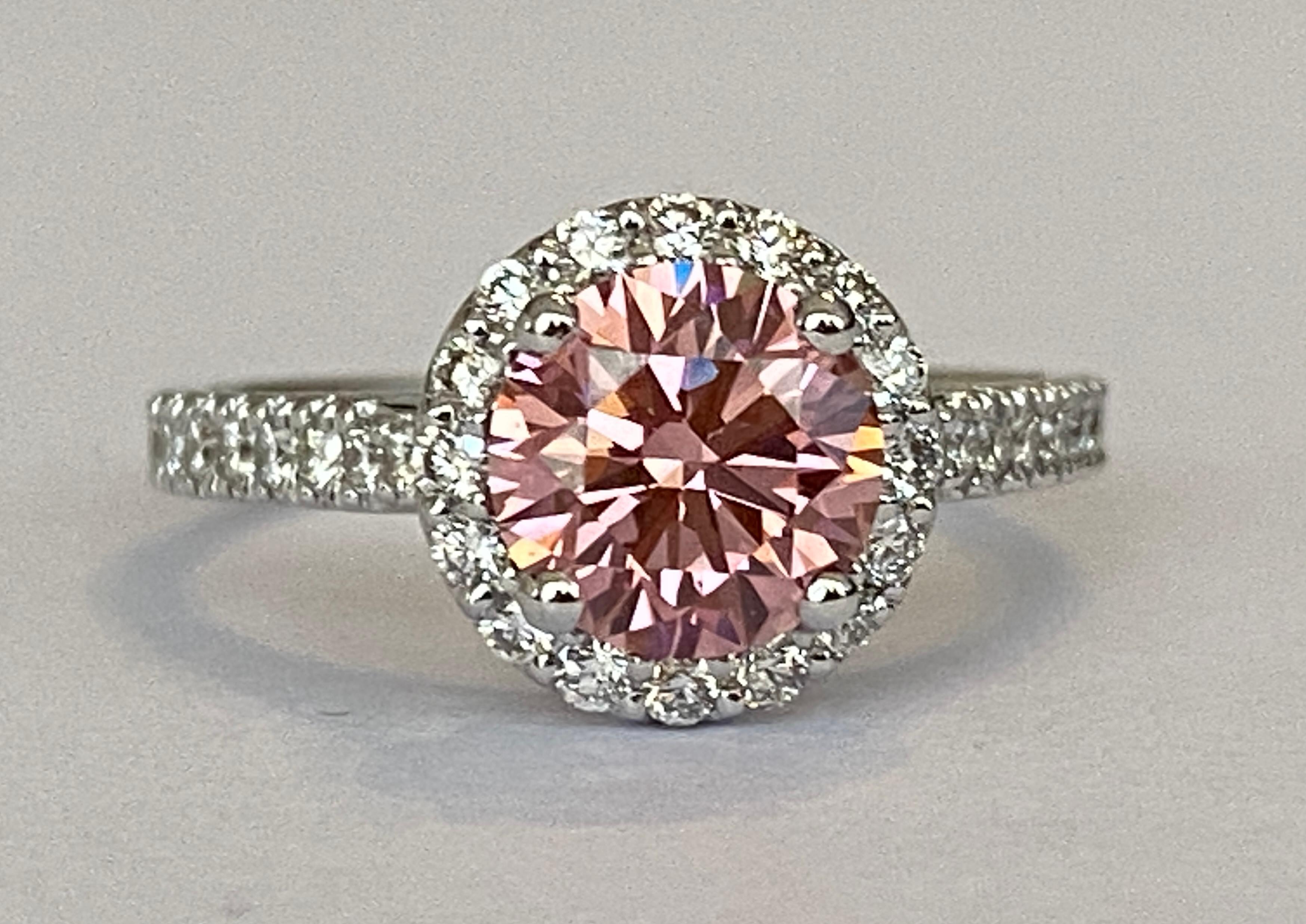Offered: 18 carat white gold solitaire ring with 1.51crt  lab created brilliant cut fansy vivid pink diamond of quality VS1 and 32 pieces of natural brilliant cut diamonds in total approx. 0.45 crt G/VS/SI. 
Grade: 18 KT (stamped 750)
Weight: 3.9