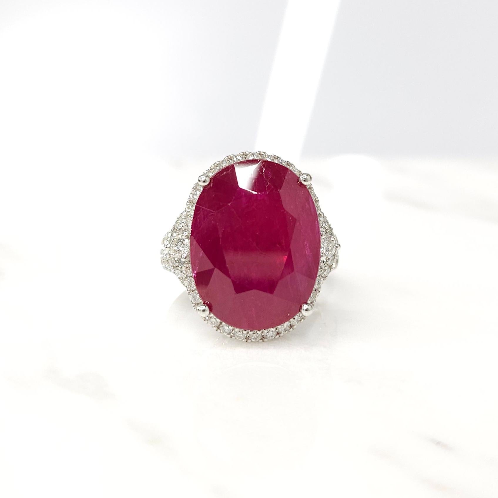 Introducing a truly extraordinary piece of jewelry, the IGI Certified 14.13 Carat Burma Ruby and Diamond Halo Ring. This ring is a testament to the unparalleled beauty and exceptional rarity of its centerpiece, a breathtaking 14.13 carat Burma