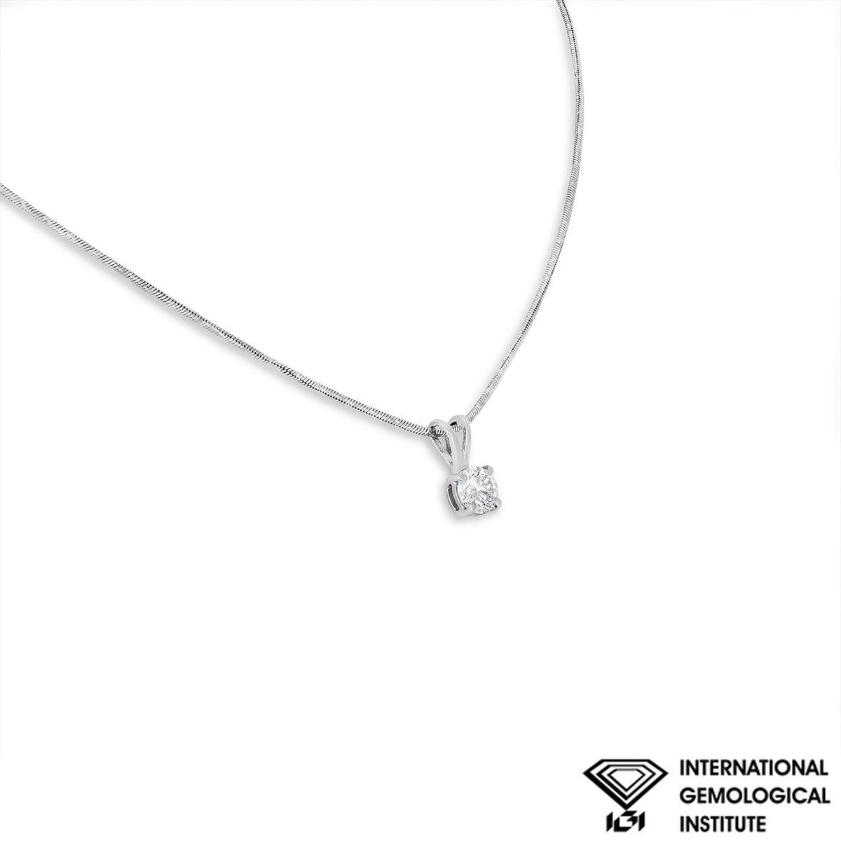 A classic 18k white gold diamond pendant. The pendant features a round brilliant cut diamond set in a four prong mount weighing 0.70ct, E colour and SI1 clarity. The pendant suspends from a textured 15-inch snake chain, finishes with a spring ring