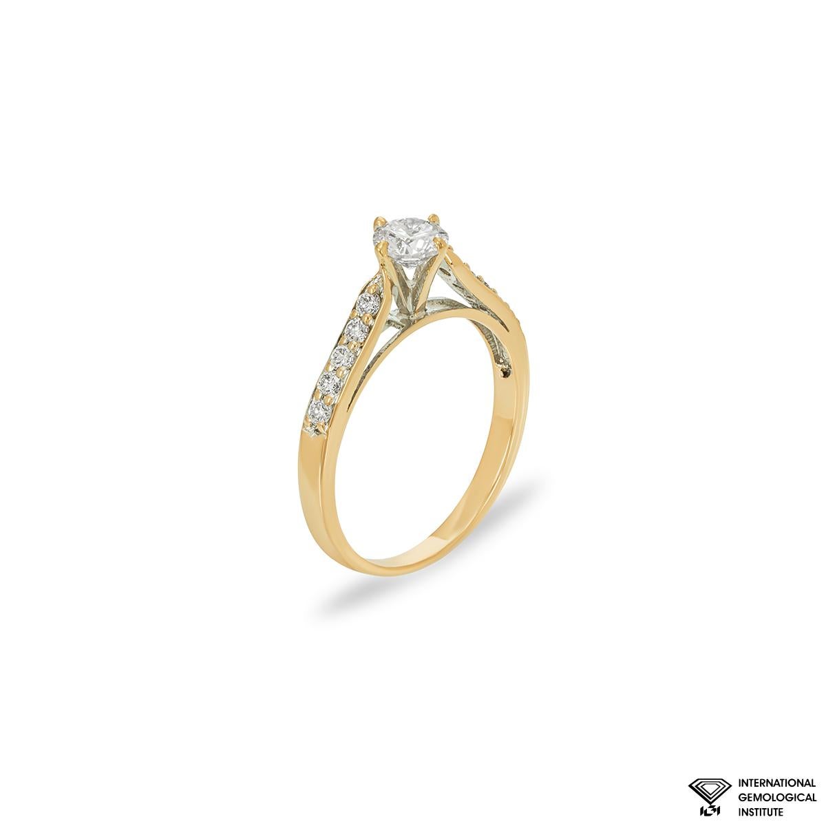 Bague de fiançailles en or jaune 18 carats avec diamant. La bague est sertie au centre d'un diamant rond de taille brillant pesant 0,52ct, de couleur rose pâle et de pureté SI2. Le diamant central est complété par 10 diamants ronds de taille
