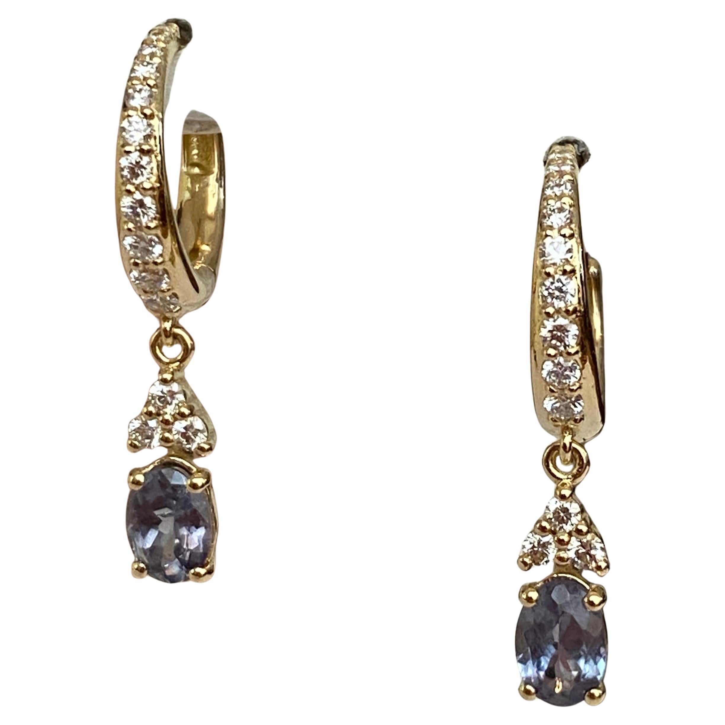 Orecchini in oro giallo con due alessandriti taglio ovale da 0,98 carati. Le pietre sono circondate da un entourage di 28 diamanti taglio brillante, per un totale di circa 0,50 carati, di qualità G/VS. Le pietre cambiano colore dal verde al viola