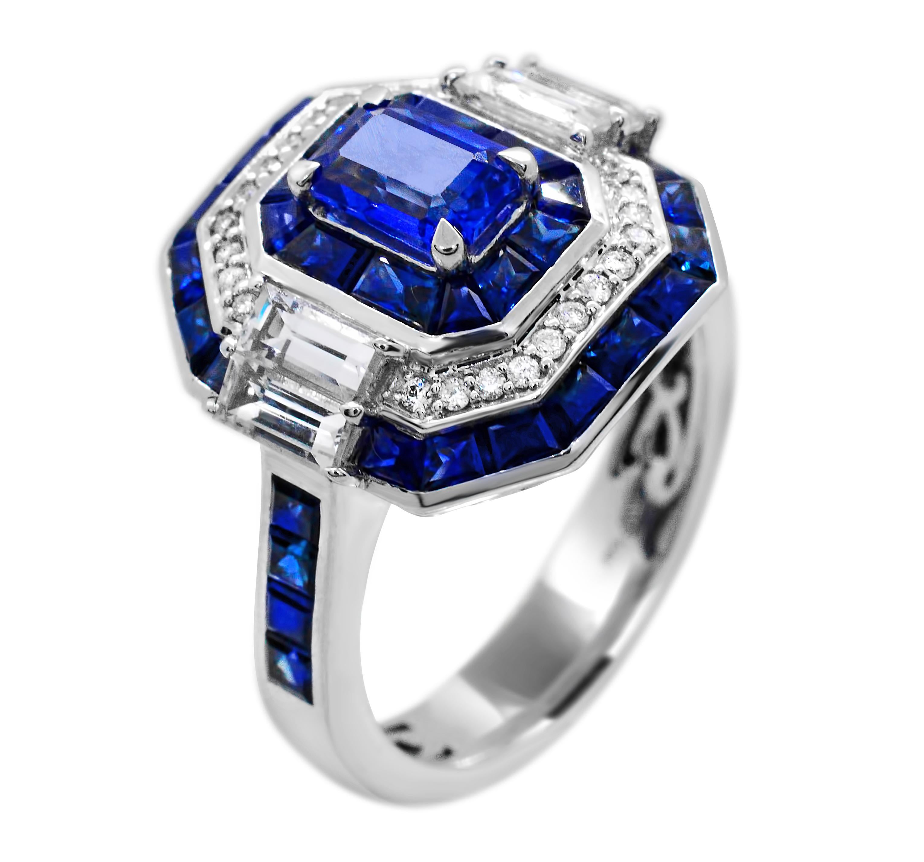 Blue and White Emerald Cut Ceylon Sapphire 14Karat White Gold Ring.  At the center of this ring, sits a beautiful 6 x 4 mm emerald-cut Ceylon Sapphire weighing a total of 0.73 Carat.  Blue and White Sapphire baguettes of varying sizes are hand-set