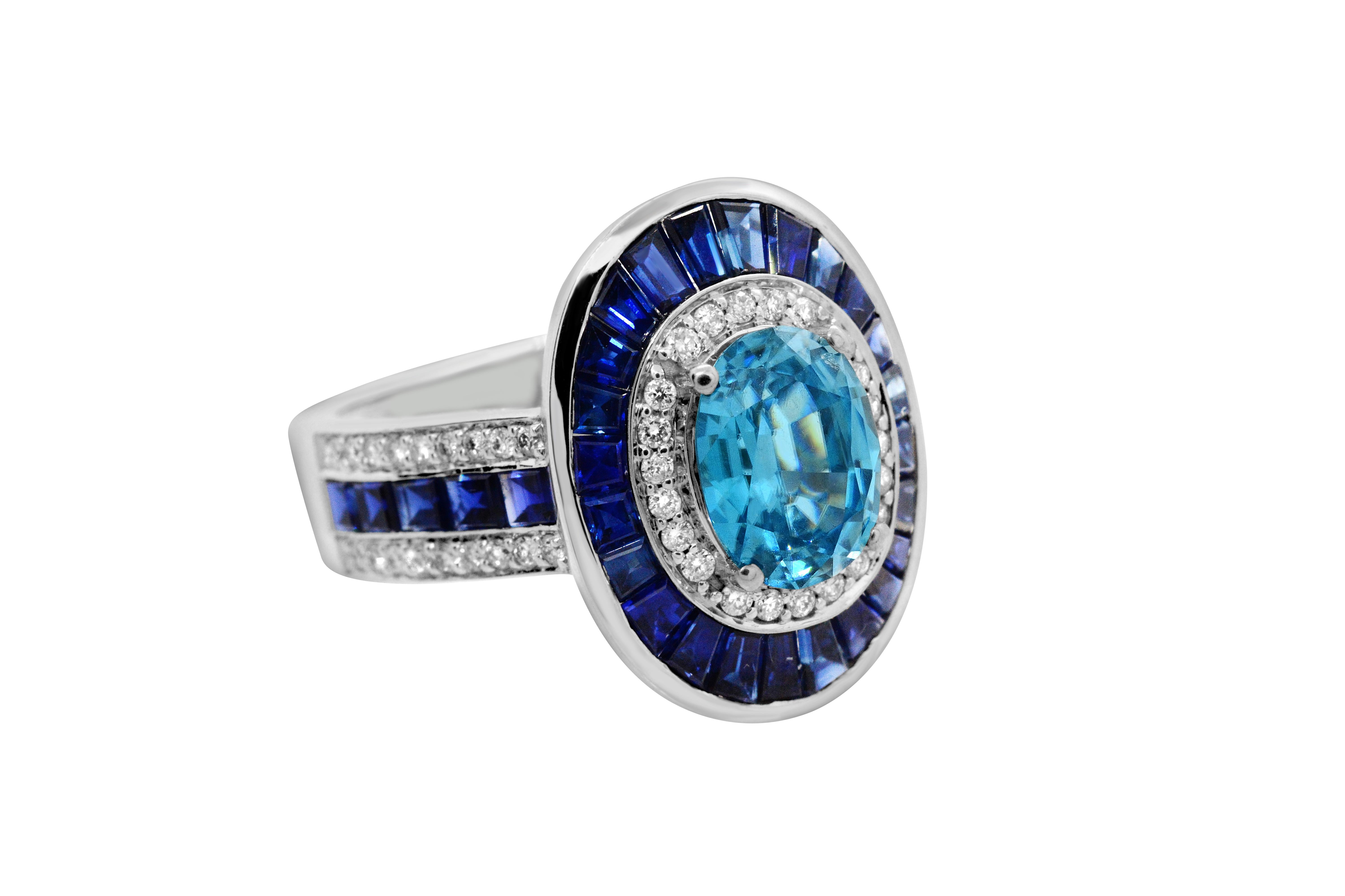 Strikingly bright Blue Zircon.  The first thing you will notice is the vivid and well-saturated 1.25 carat oval Blue Zircon.  It is perfectly encircled by 2.85 carats of tapered baguette Blue Sapphires and Diamonds that weight a total of 0.30 carat