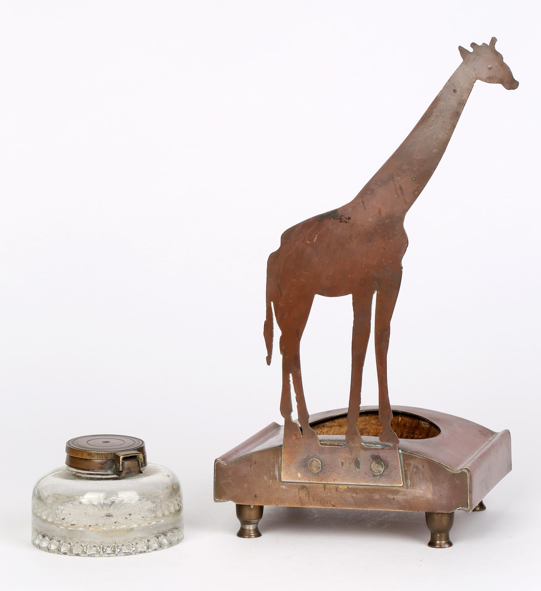 Jugendstil German copper giraffe mounted ink stand by Ignatius Taschner (German, 1871-1913) dated 1905. This rare ink stand comprises of a wooden block set within a copper surround with a central mounted removable lidded glass inkwell. The stand has