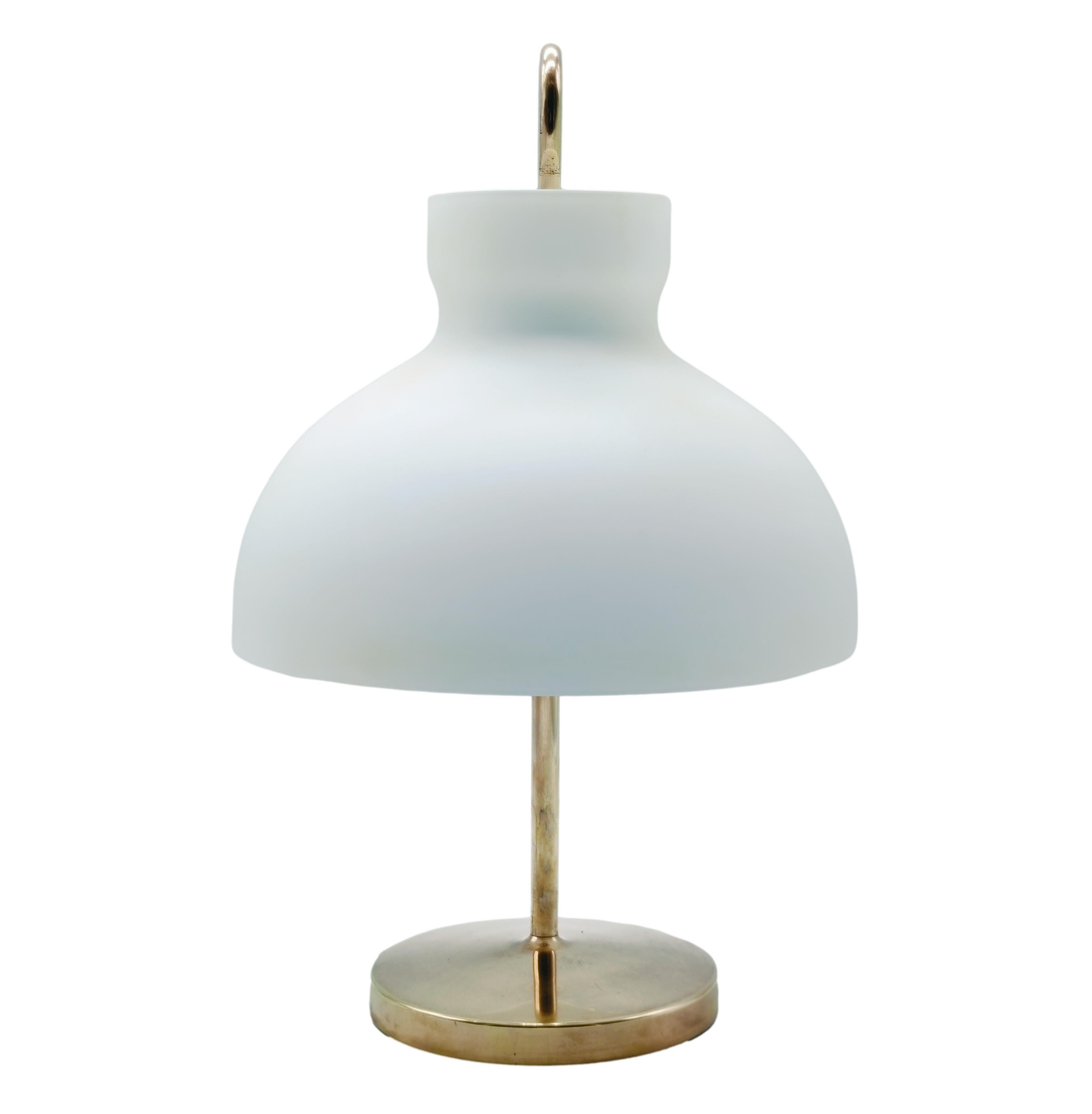 Lampada da tavolo 'Arenzano Bassa' di Ignazio Gardella in ottone e vetro.
Nel 1956 il maestro Ignazio Gardella crea la lampada Arenzano. La intitolò alla località balneare ligure dove progettò e realizzò numerosi edifici per lo stabilimento milanese
