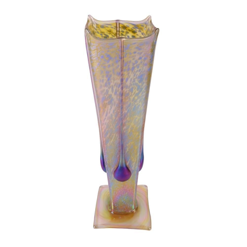 Presenting this large, Igor Muller art glass vase. Vase is decorated with a mottled, green and yellow “spotted” iridescent body featuring four iridescent peacock blue elongated “pod” designs on a square base. This vase is in excellent condition with