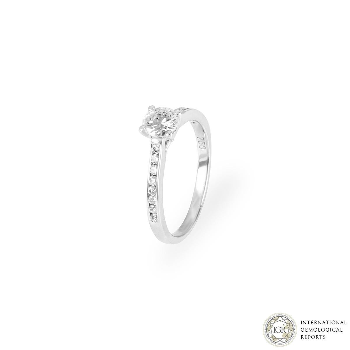 A beautiful 18k white gold diamond engagement ring. The engagement ring is set to the centre in a four claw mount with a round brilliant cut diamond weighing 0.52ct, D colour and VS1 clarity. The diamond is further complemented by 16 round brilliant