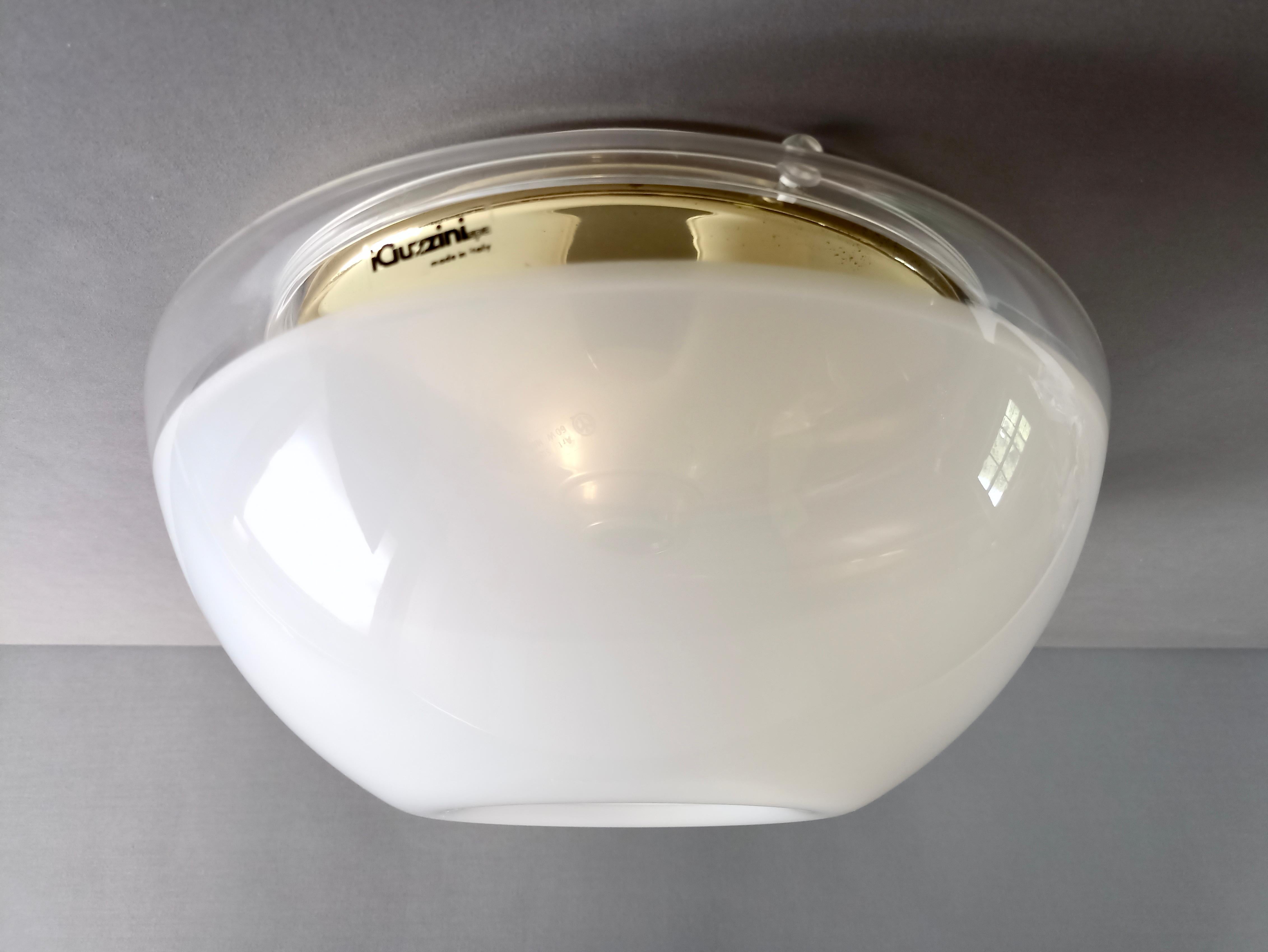Rare and original 1970s iGuzzini one-light ceiling lamp in plastic and brass. The lampshade near the base at the top has a transparent band and is instead white towards the bottom so as to create a beautiful light effect. The shade is mounted