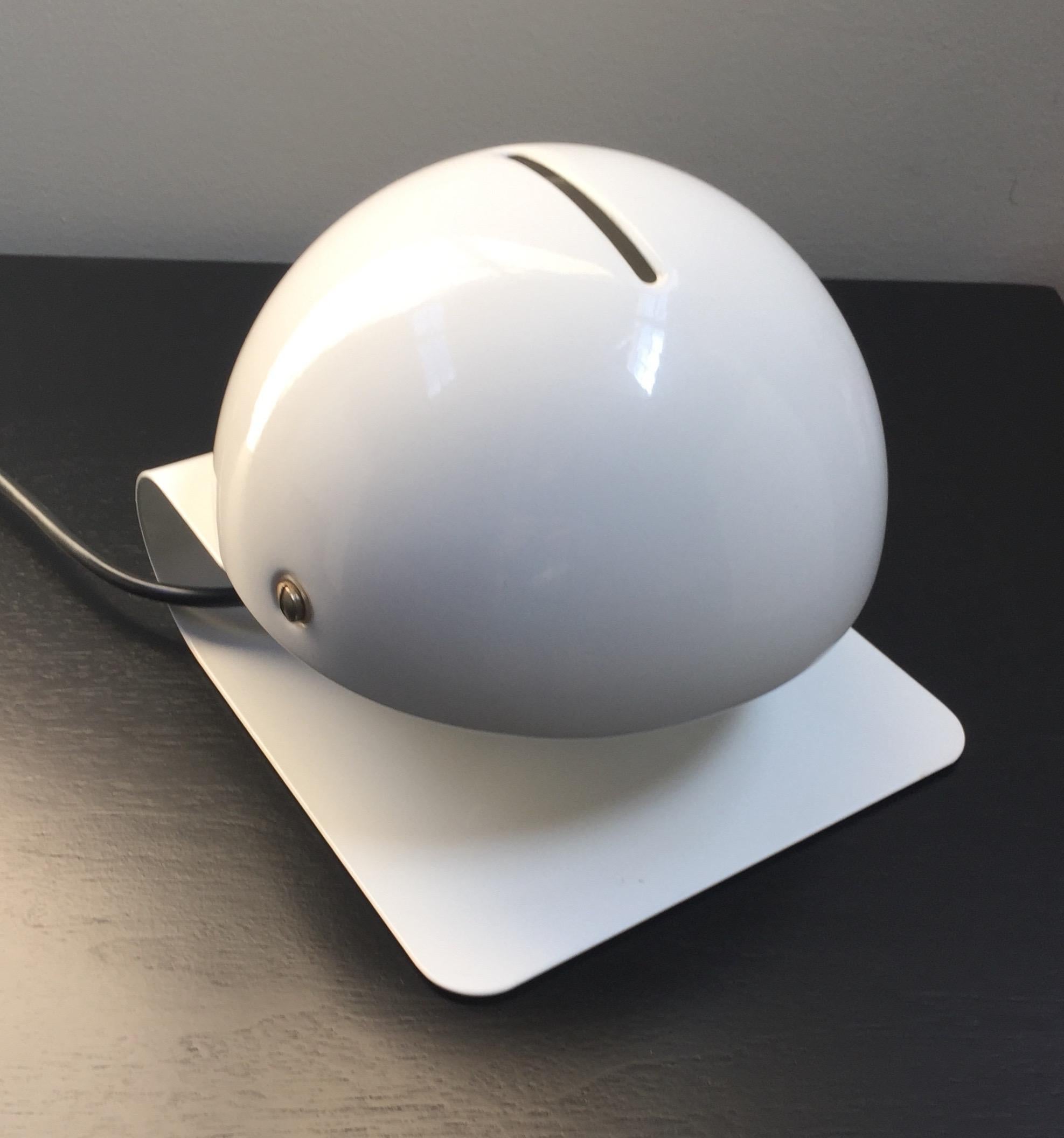 White enamel table lamp with a shade that swivels to adjust the level of light.