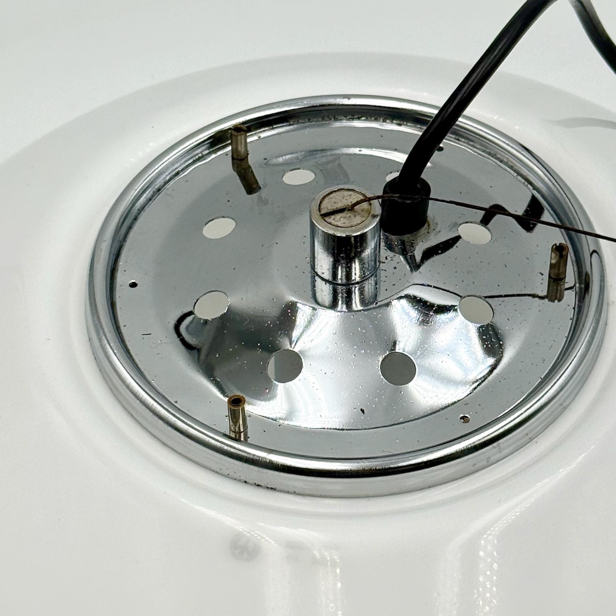 lampada a sospensione originale A Space Age di iGuzzini, modello Art. 3072, realizzata in Italia negli anni '70.

Con il suo diffusore in metacrilato bianco opalino e i dettagli in metallo cromato, questo pezzo riflette l'estetica futuristica tipica