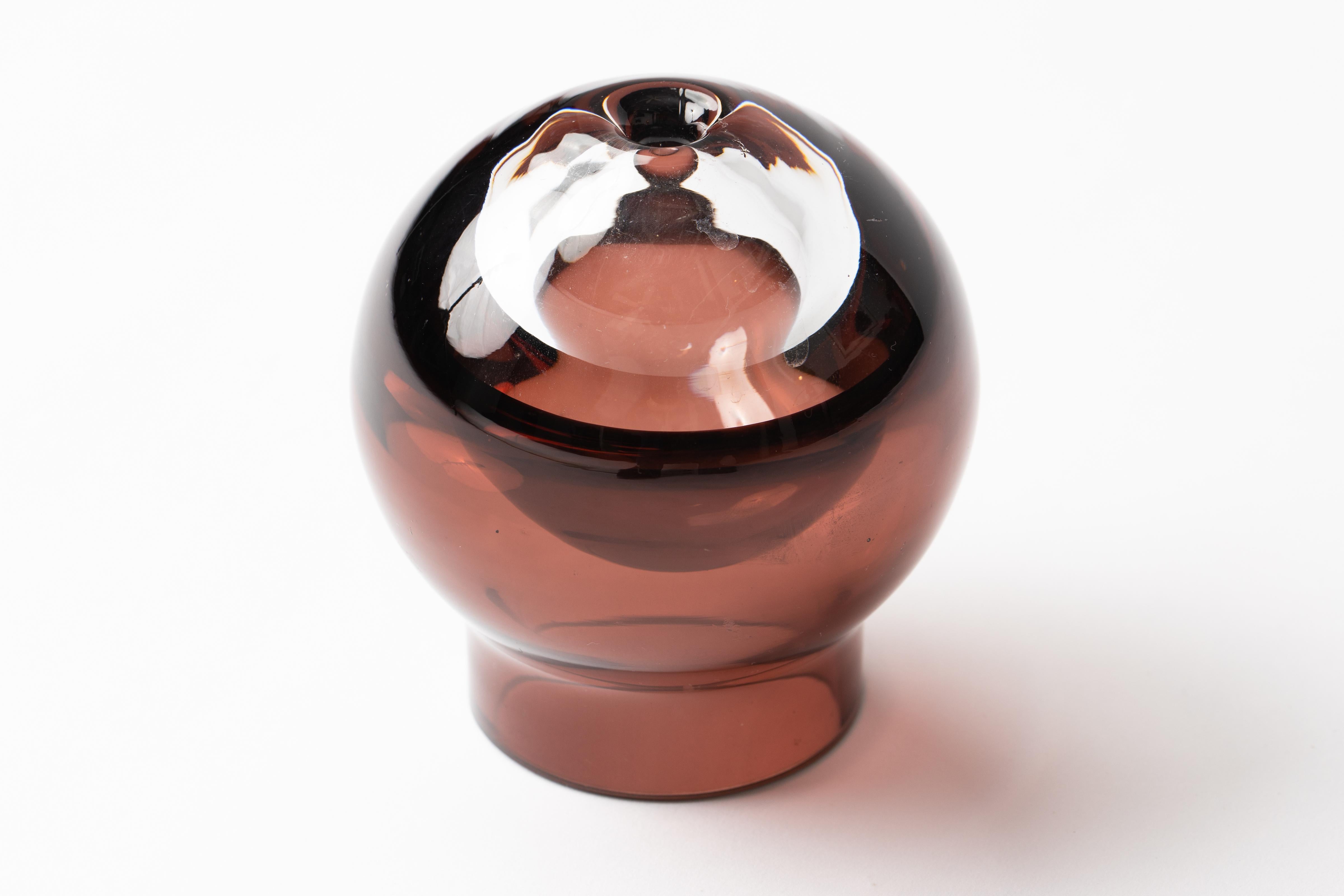 Vaso di gemme scandinavo in vetro convesso viola e trasparente.
Il vetro è realizzato per riflettere la luce grazie alla sua sfera convessa e al suo design ottico. Attribuito a Iittala Tantrapanto, Finlandia.