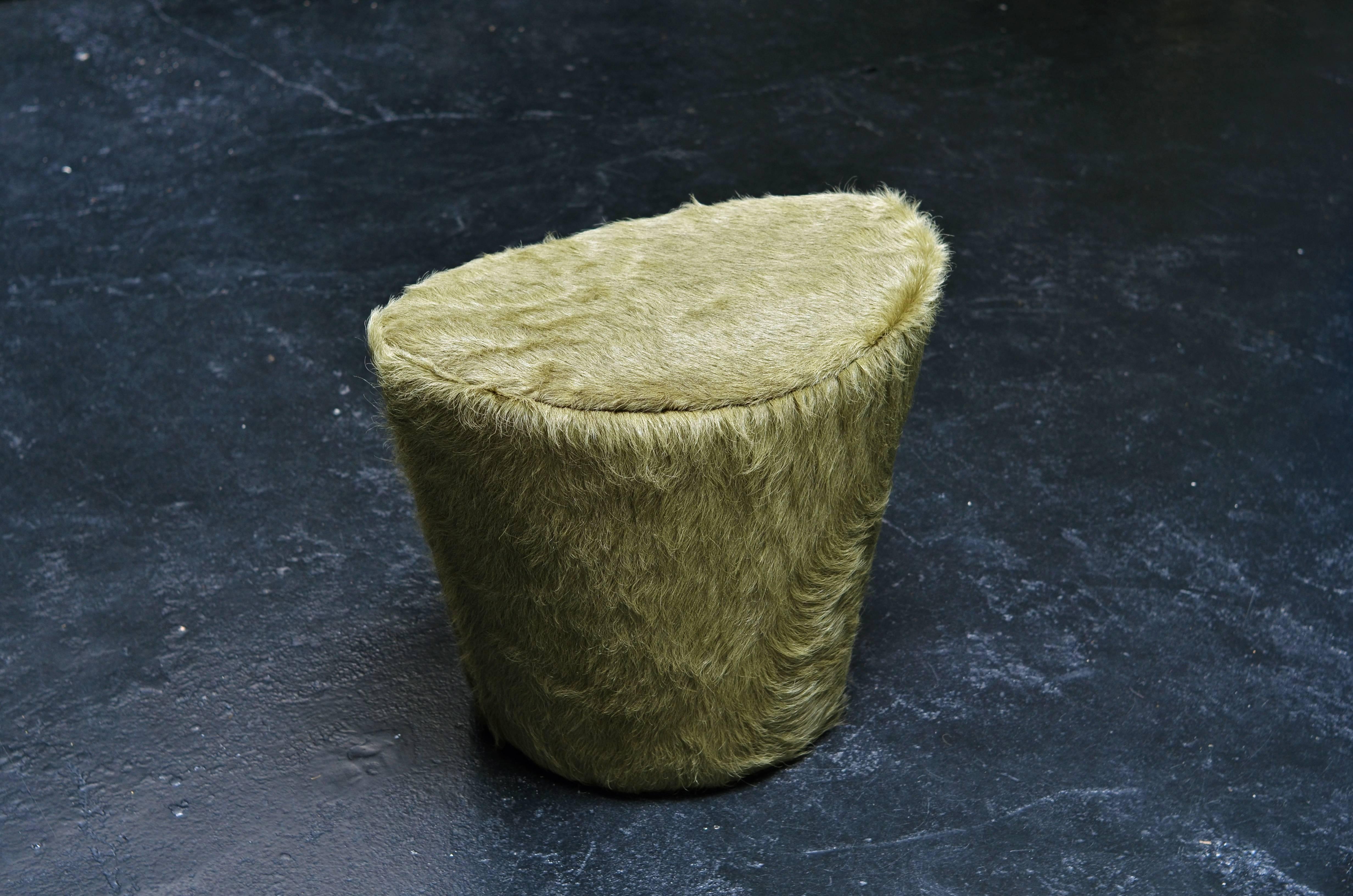 The Ikaros stool is part of a three-type upholstered cowhide series: polygonally shaped poufs (large and small), a curvilinear stool, and oval bench; each one encased in a distinctive cowhide cover. Created to either place in front of a couch in the