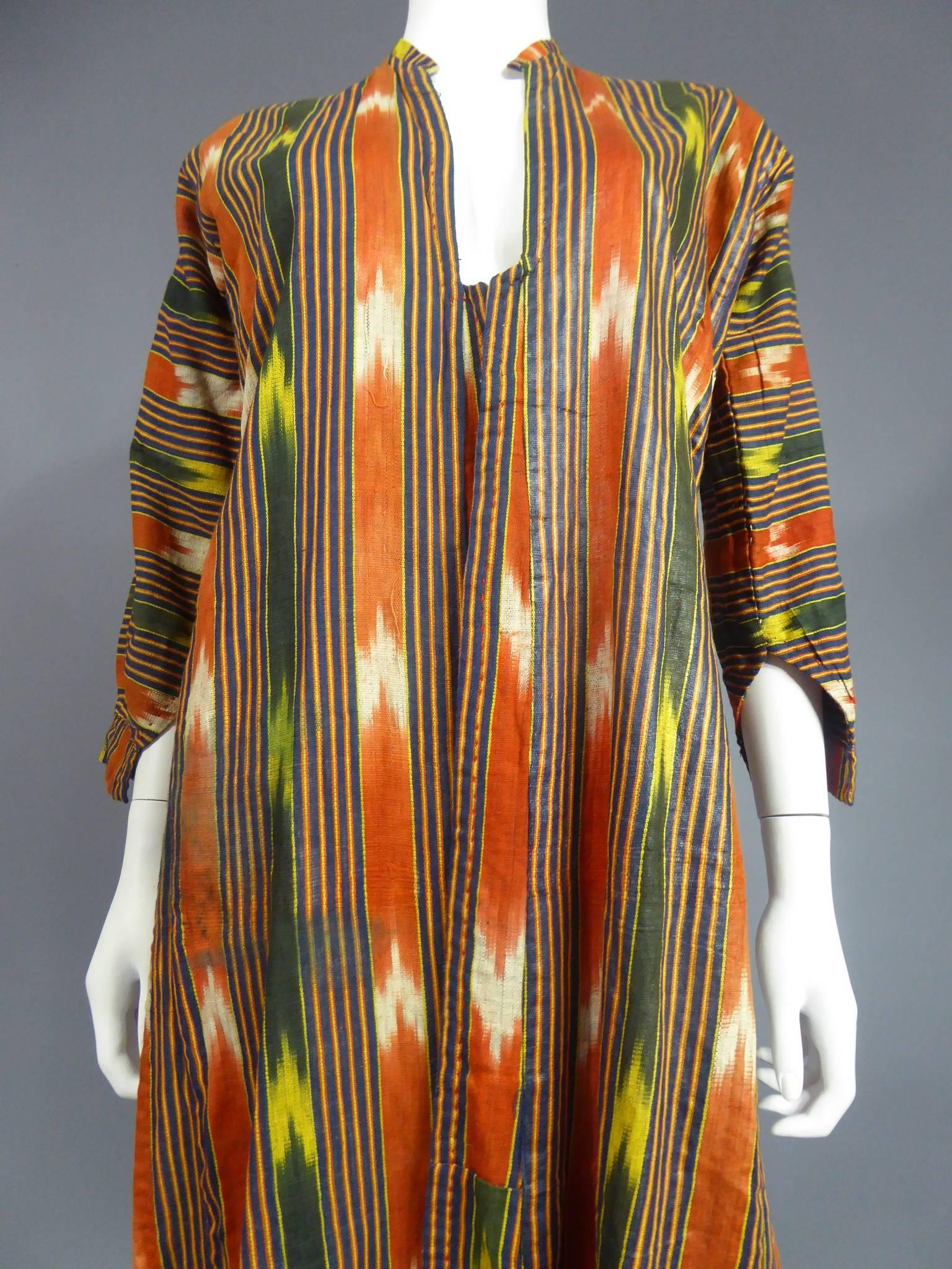 Early 20th century

Ottoman Empire

Beautiful feminine Kaftan in iced cotton ikat dating from the first third of the twentieth century. Background with broad orange and green stripes ikatées of white and yellow curry, alternating with fine red and