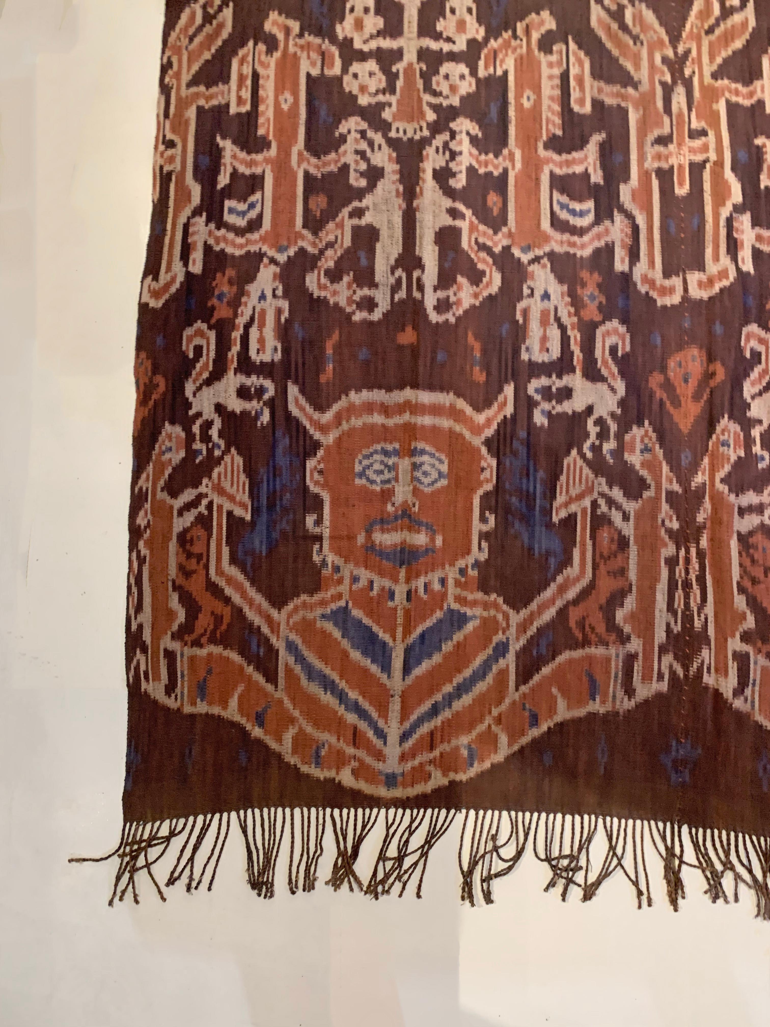 Dieses Ikat-Textil stammt von der Insel Sumba in Indonesien. Es wird mit natürlich gefärbten Garnen nach einer seit Generationen überlieferten Methode handgewebt. Es zeigt eine atemberaubende Vielfalt von Stammesmustern und -motiven. Es sind die