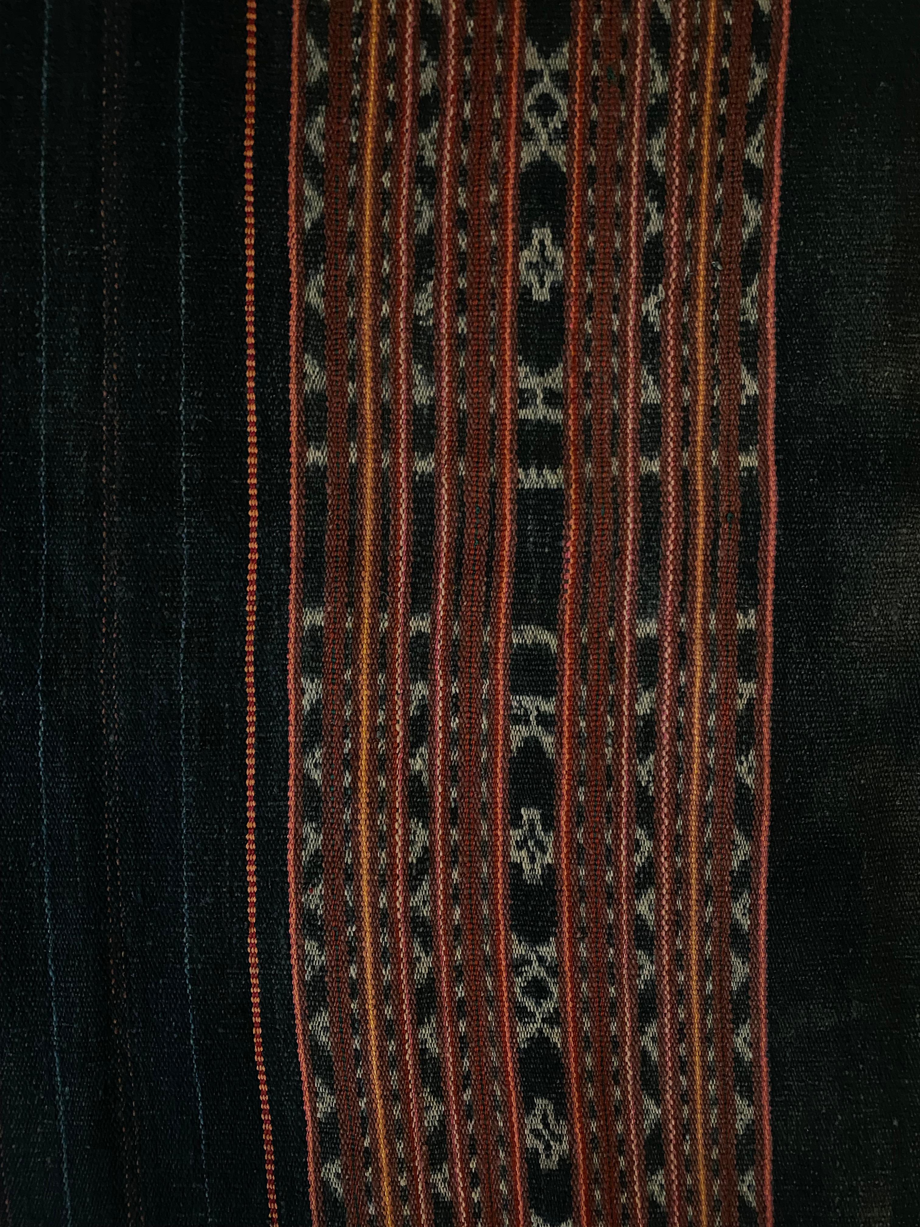 This Ikat textile originates from the Island of Timor, Indonesia. It is hand-woven using naturally dyed yarns via a method passed on through generations. The dark blue foreground brings to life the array of coloured detailing and distinct tribal