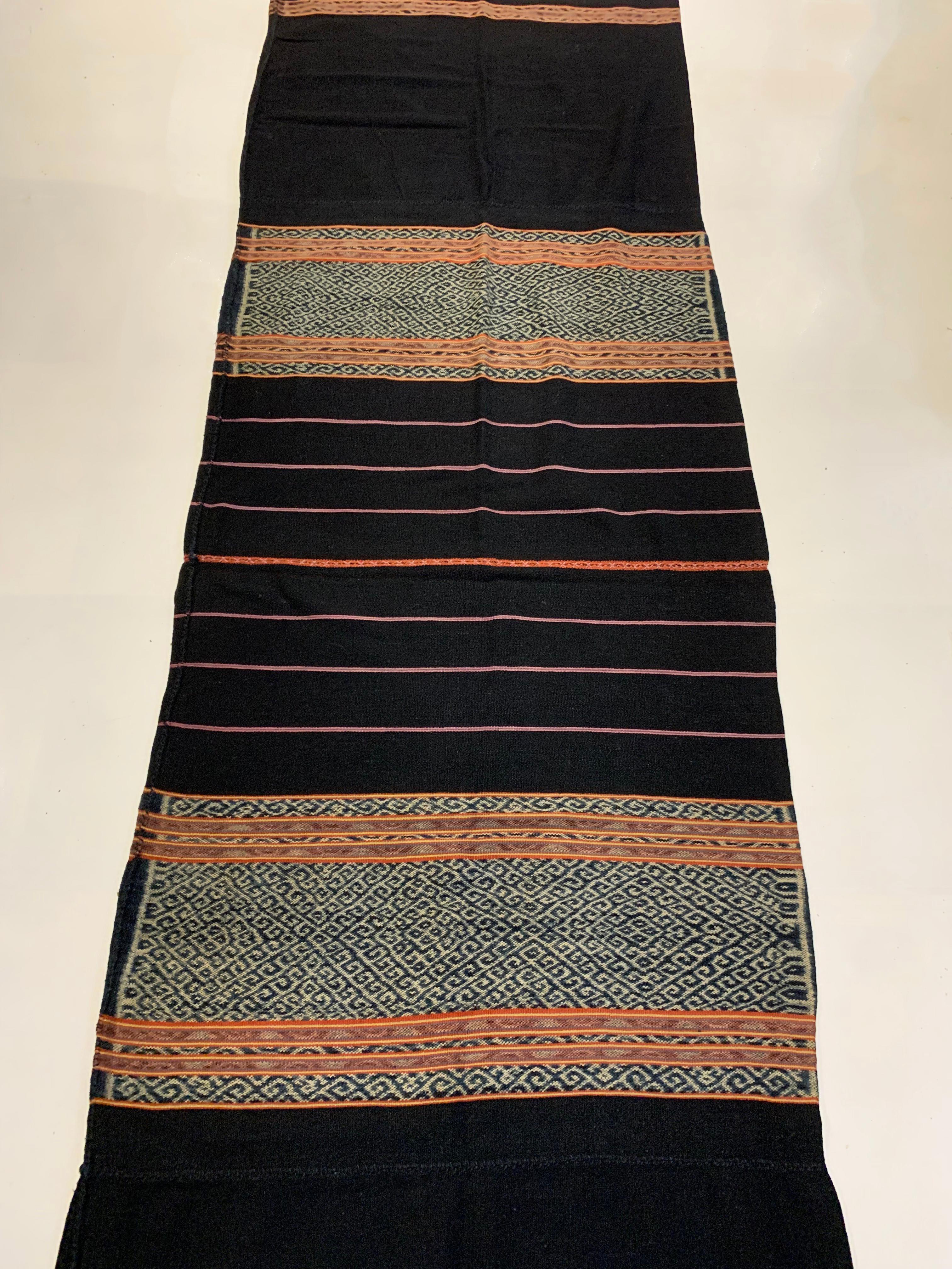 This Ikat textile originates from the Island of Timor, Indonesia. It is hand-woven using naturally dyed yarns via a method passed on through generations. The dark background brings to life the array of coloured detailing and distinct tribal