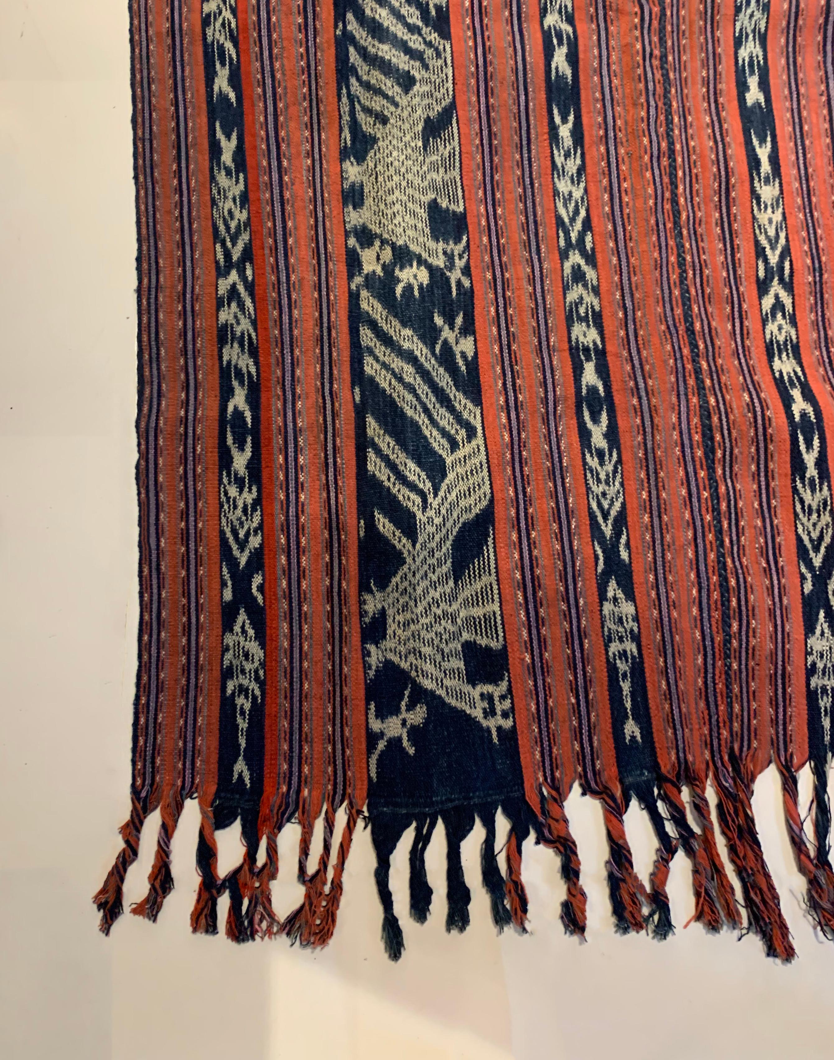 An wonderful example of a west timor ikat textile. It is hand-woven using naturally dyed yarns via a method passed on through generations. It features a stunning array of distinct tribal patterns and bright colours. The outter bands feature chicken