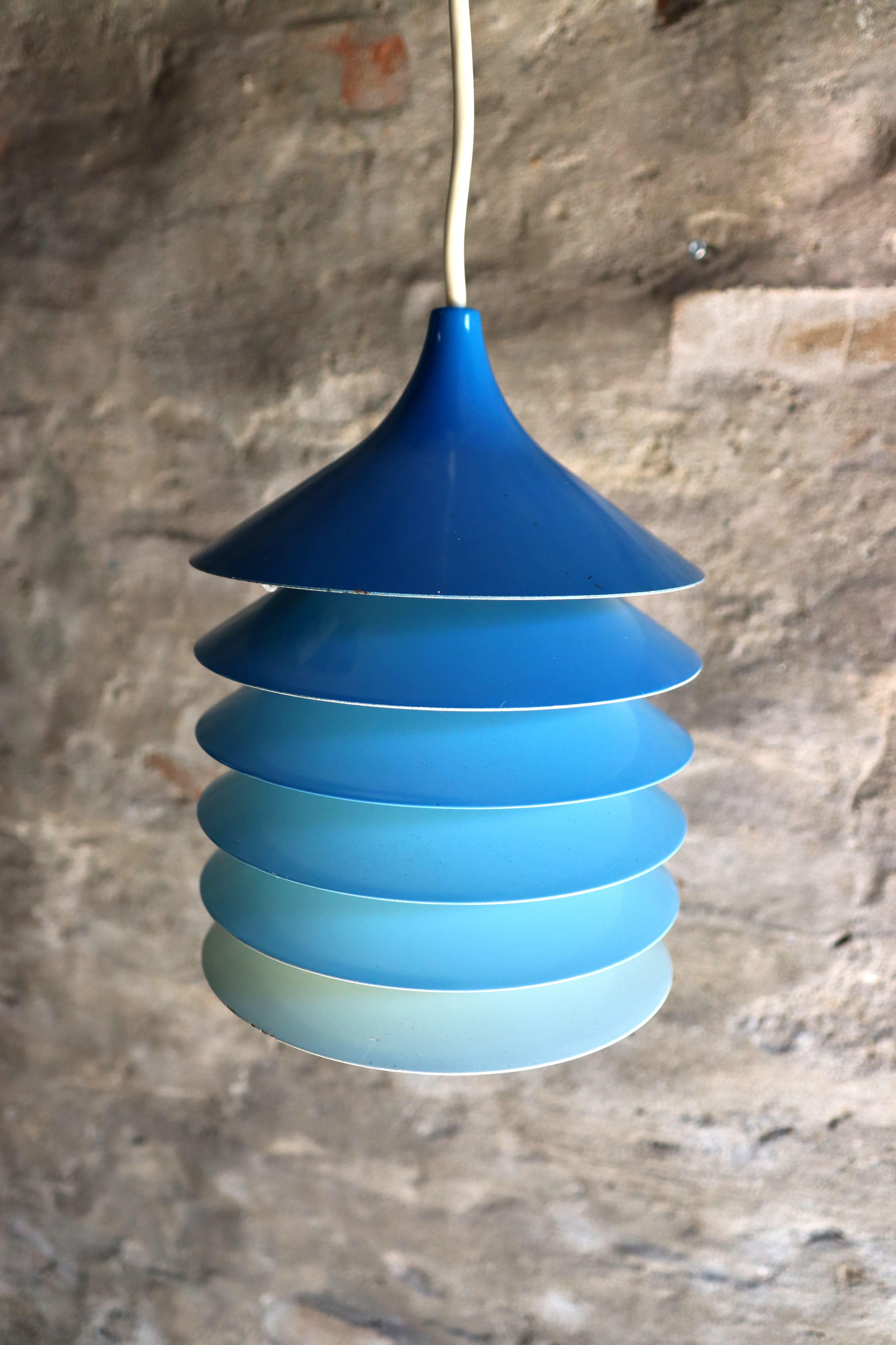 Materials: White round metal (aluminium) stacking discs lampshade. Painted in blue color gradient.
Period: 1980s.
Designer: Bent Gantzel-Boysen in 1983.
Manufacturer: IKEA
Other versions: The IKEA Duett pendant lamp exists in white, blue, red,