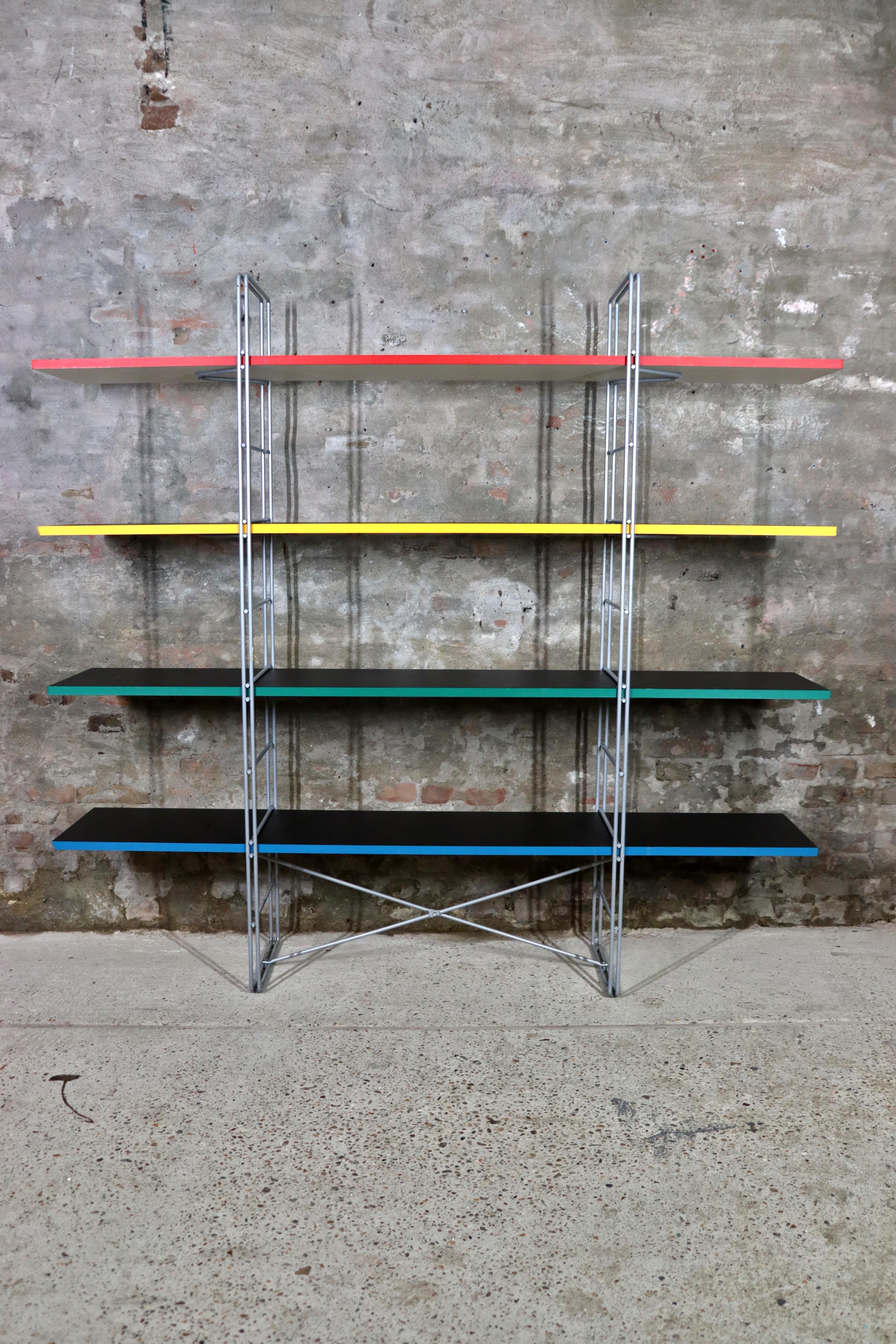 Shelving System Guide by Niels Gammelgaard for Ikea in 1985. The metal structure is in grey lacquered steel and supports the shelves. The shelves are colored on one side and white on the other. Good condition, but there are signs of usage and wear