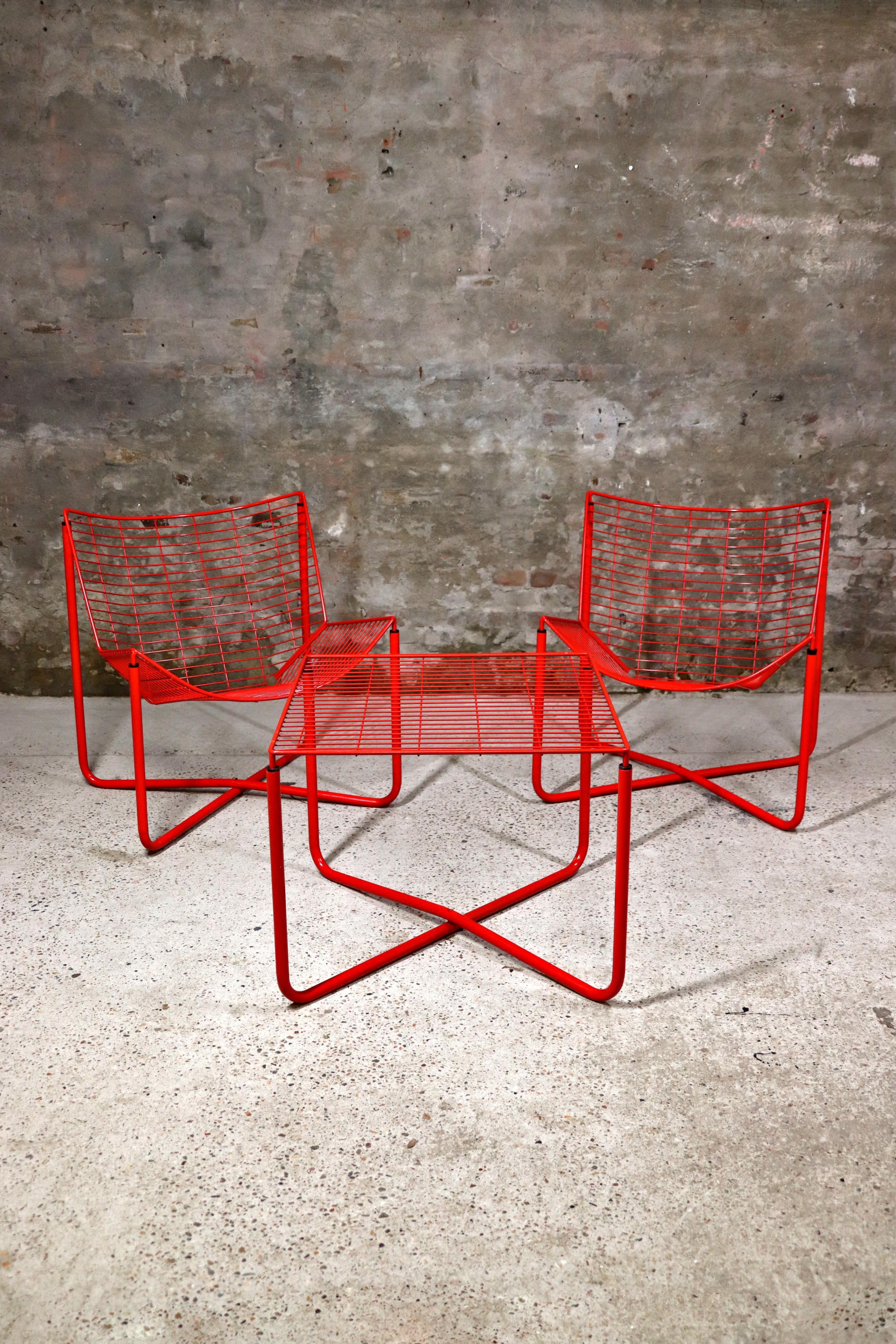 2 sillas Jarpen rojas y 1 mesa del diseñador sueco Niels Gammelgaard para IKEA en 1983. Tanto las sillas como la mesa se han fabricado con una sola pieza de chapa de alambre. Tanto las sillas como la mesa están en muy buen estado.. Sólo un par de