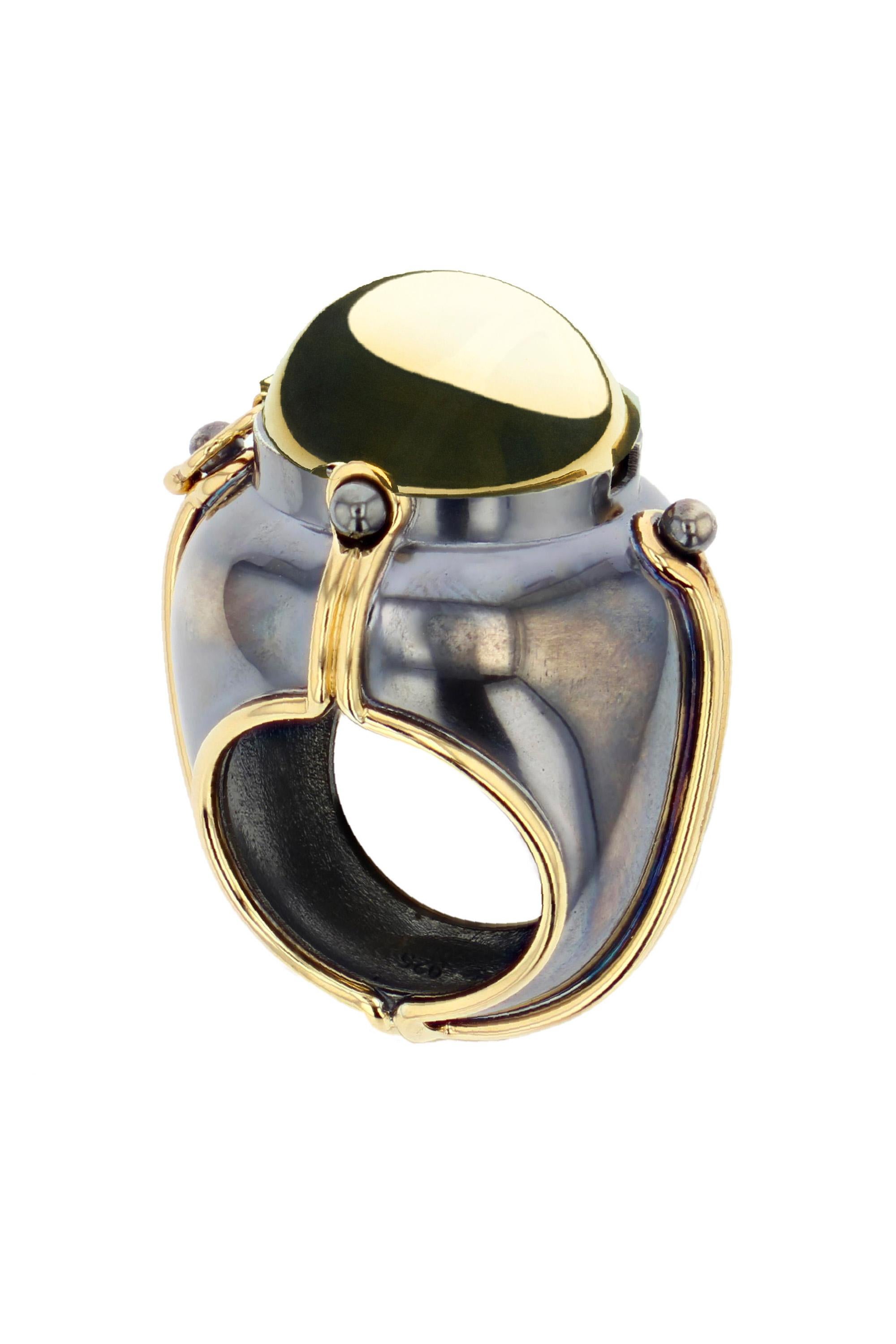 Gold and distressed silver ring. Rotating sphere revealing an Œil de Tigre, encircled by a white gold ring set with a diamond.

Details:
Œil de Tigre: ø 14 mm 
Diamond: 0.03 cts 
18k Gold: 12 g
Distressed Silver: 10 g
Made in France

