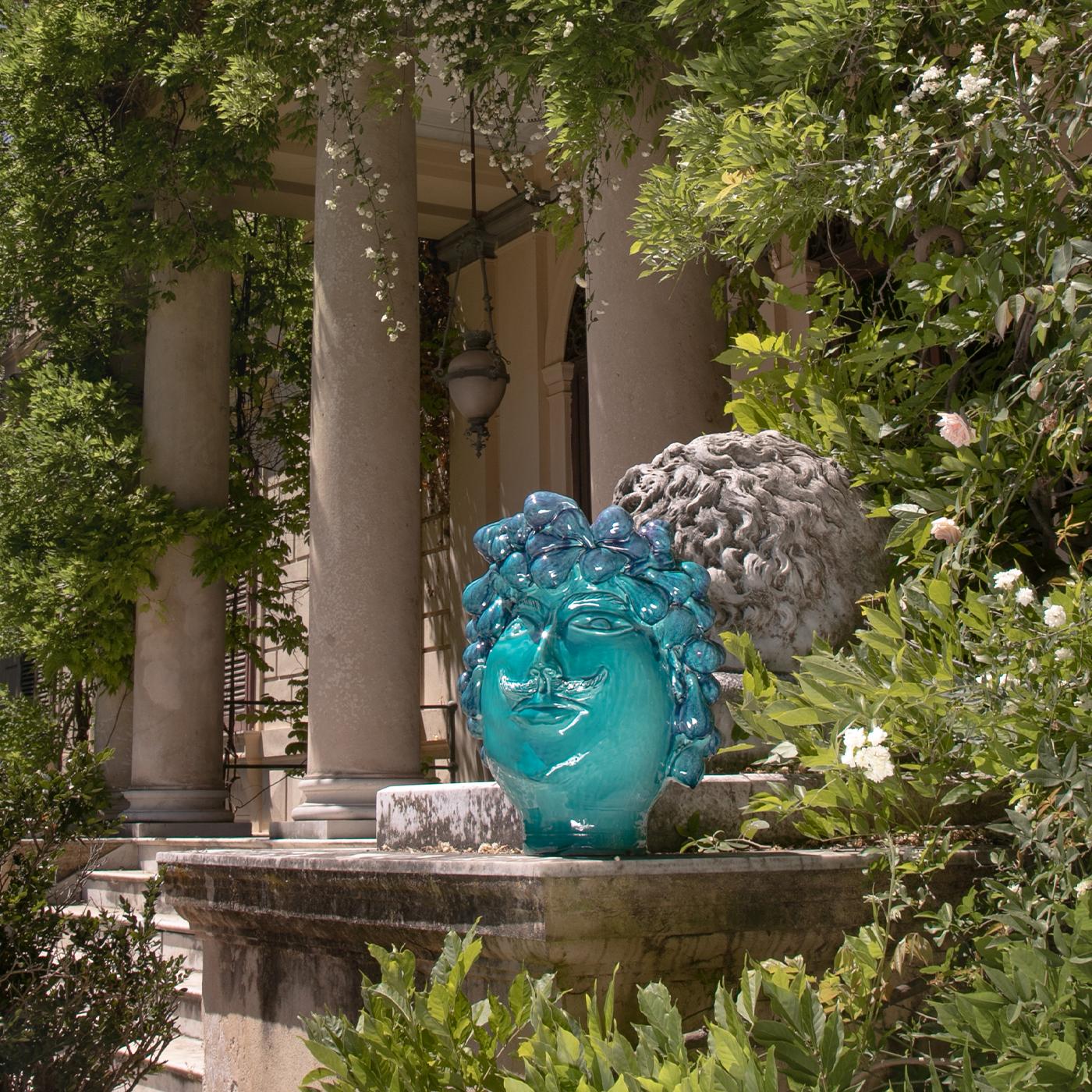 This gorgeous Moor's head from the Sicilian tradition is characterized by an extraordinary wreath made of 120 figs in relief, sculpted and decorated by hand in fine shades of crystalline blue, blue, and turquoise. Either used as a decorative head or