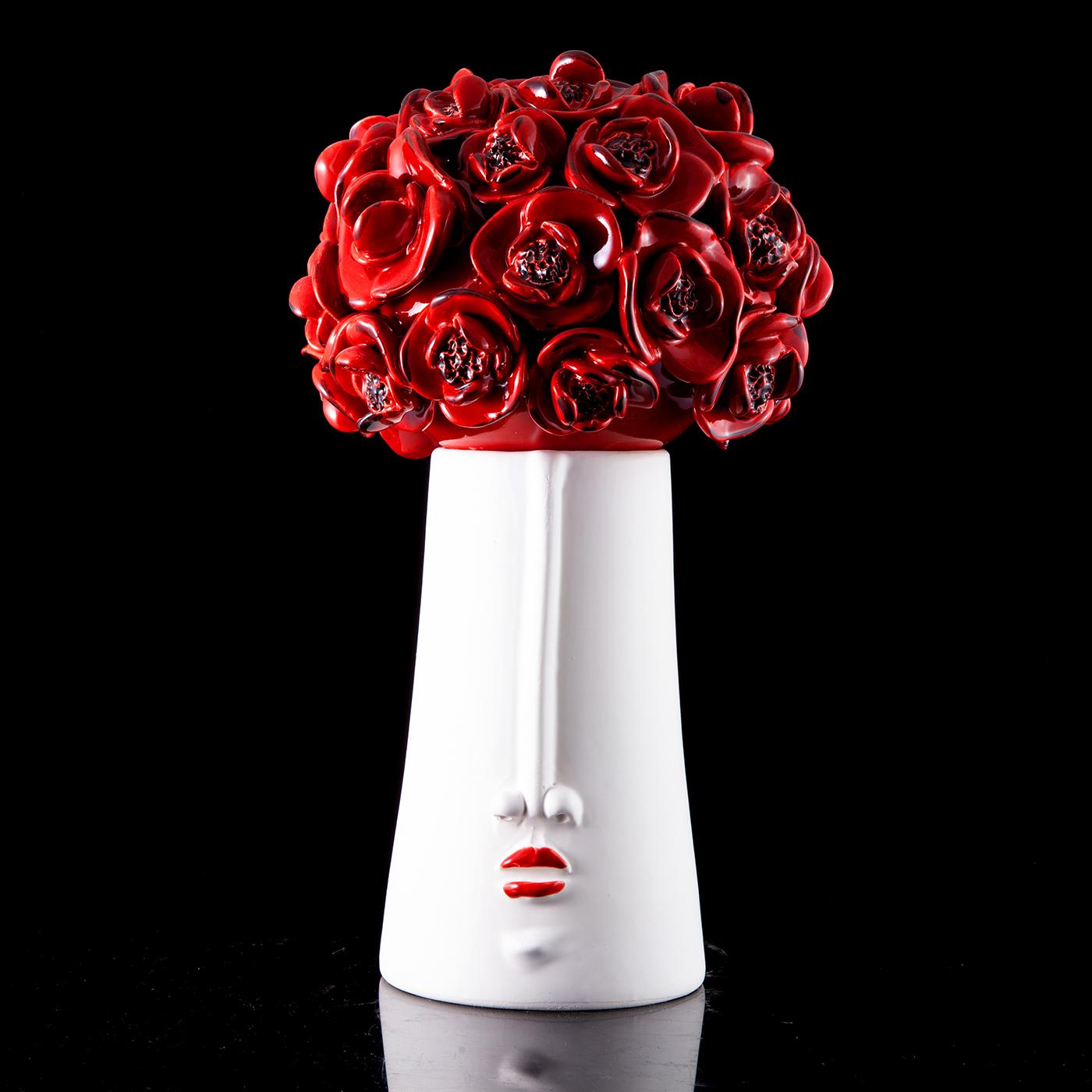 Marked by anthropomorphic traits immediately revealing its playful sculptural allure, this ceramic piece will be a precious ornament for the table. A bouquet of vibrant-red poppies gets sculpted from the lid, which lifts to reveal a practical a wide
