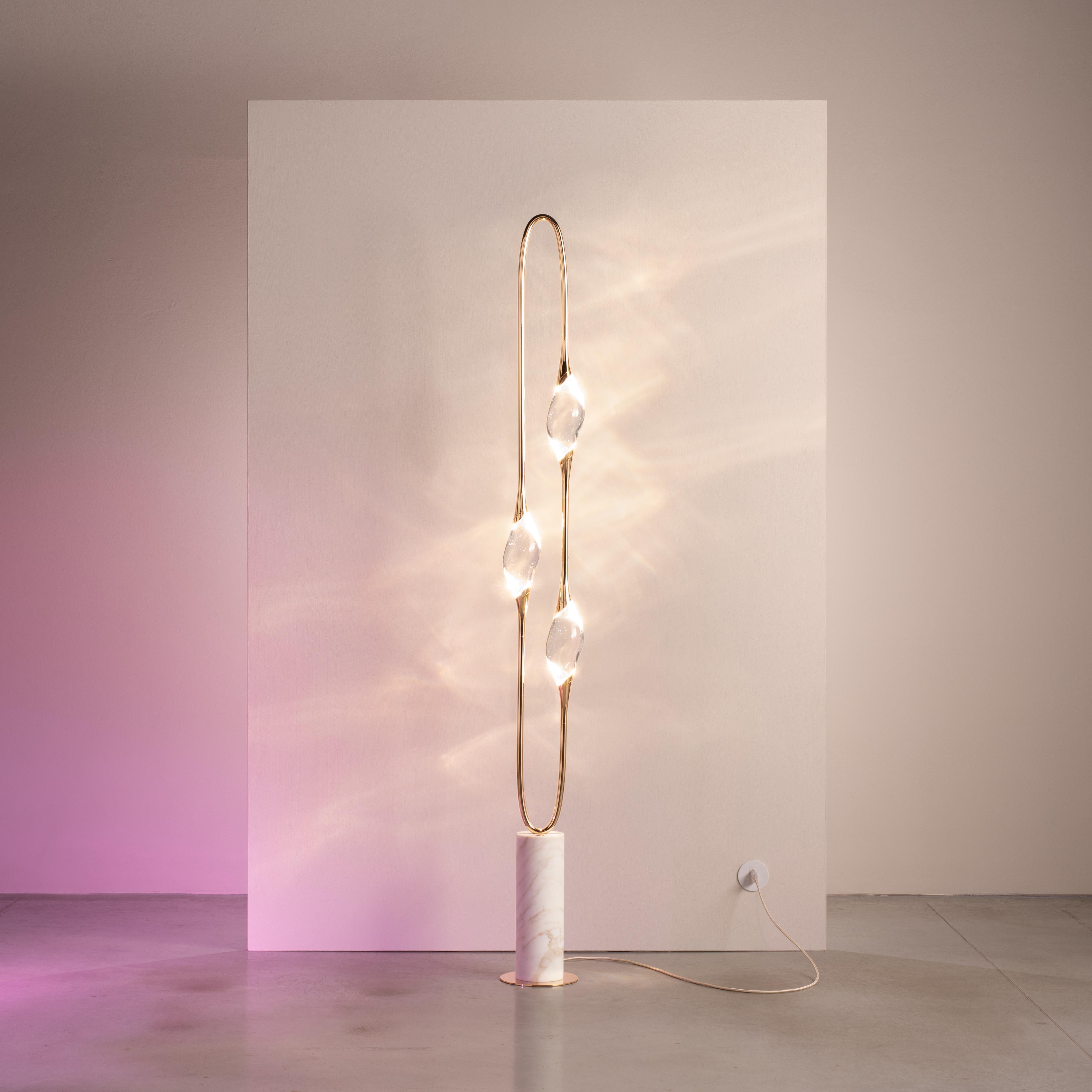 La lámpara de pie Il Pezzo 12 tiene una impresionante forma circular que lleva las tres fuentes de luz en su rotación sin fin, apoyada en una base de mármol que realza
su limpieza y pureza. Iluminados por LED, los tres cristales macizos crean un