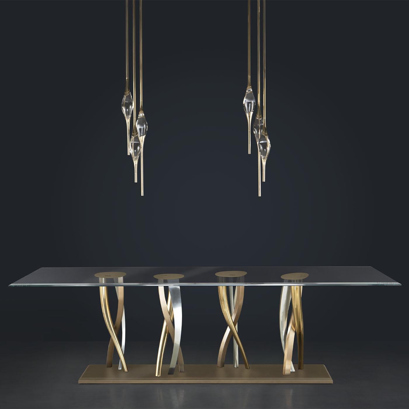 La table en verre il pezzo 8 présente un plateau en verre transparent associé à une base remarquable composée de pieds torsadés dans des finitions bronze, laiton satiné et nickel. Fabriqués selon des techniques traditionnelles de moulage au sable,