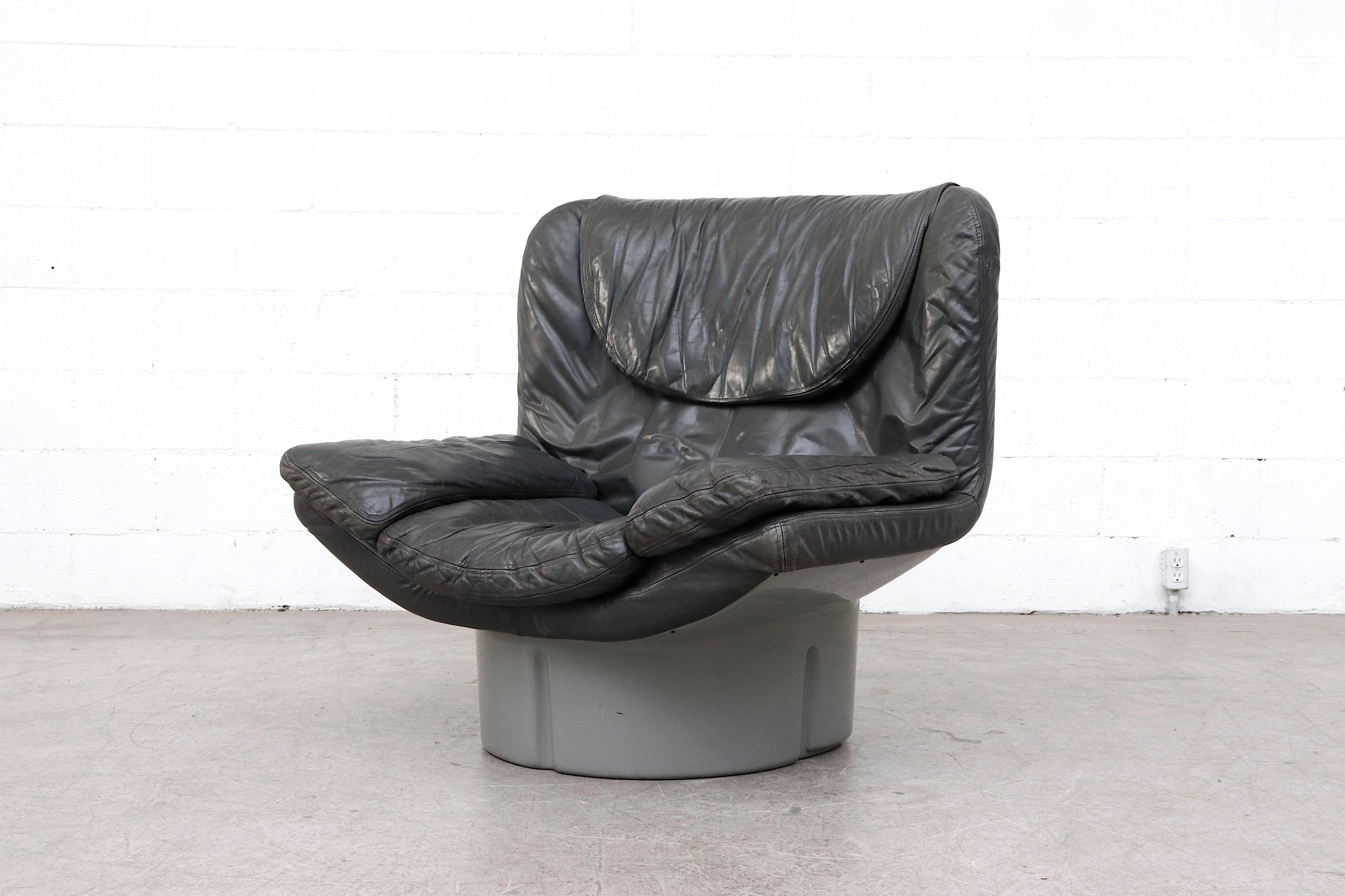Il Poltrone lounge chair as part of the i Potoni 175 series designed by T. Ammannati and G.P. Vitelli. Dark grey leather with steel grey molded acrylic base. Superbly comfortable lounger in black leather. Some visible color fading and patina on
