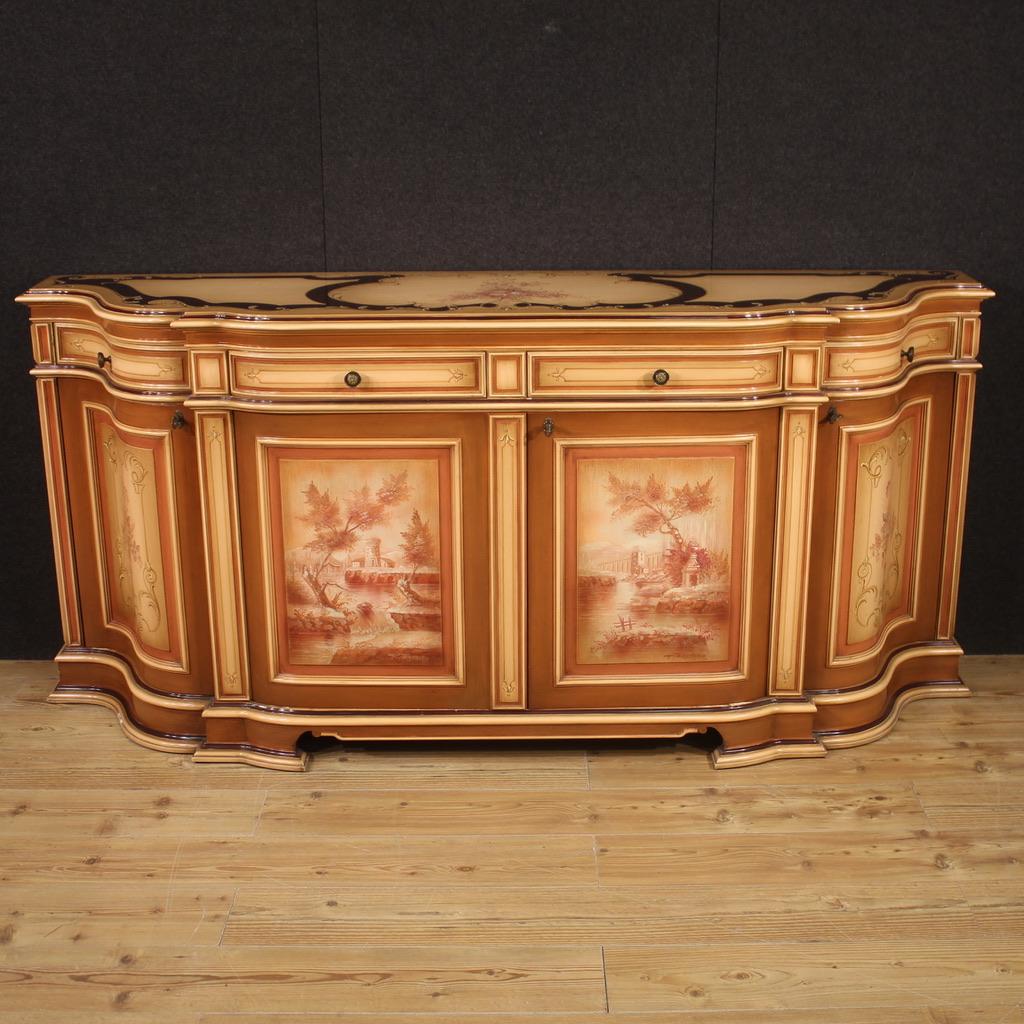 Venetian lacquered sideboard from the second half of the 20th century. Furniture of great size and impact in carved, lacquered and hand painted wood with landscapes and floral decorations (see photo). Sideboard with 4 doors and 4 drawers of