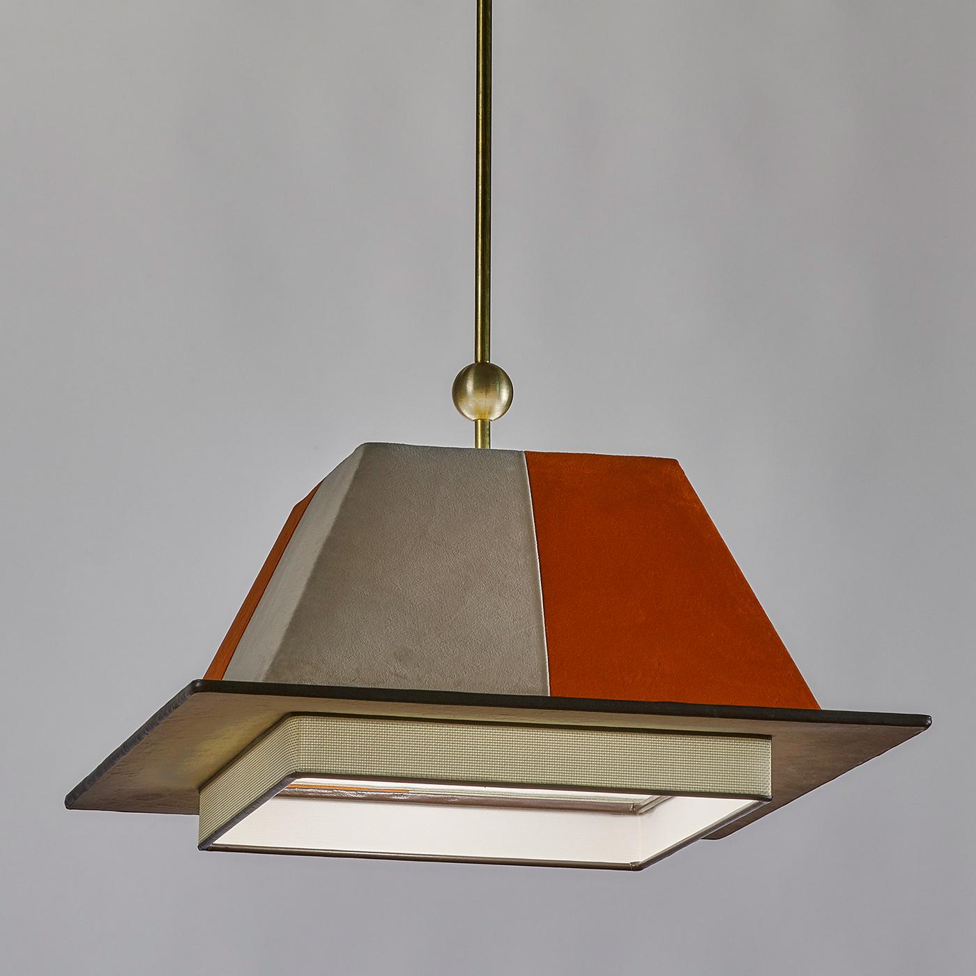 Reminiscent of the shape of the traditional graduation cap, this elegant pendant light of the Chapeau Collection (hat in French) has a trapezoidal top in alternating sections of orange and putty-gray velvet. Resting on the square frame with a