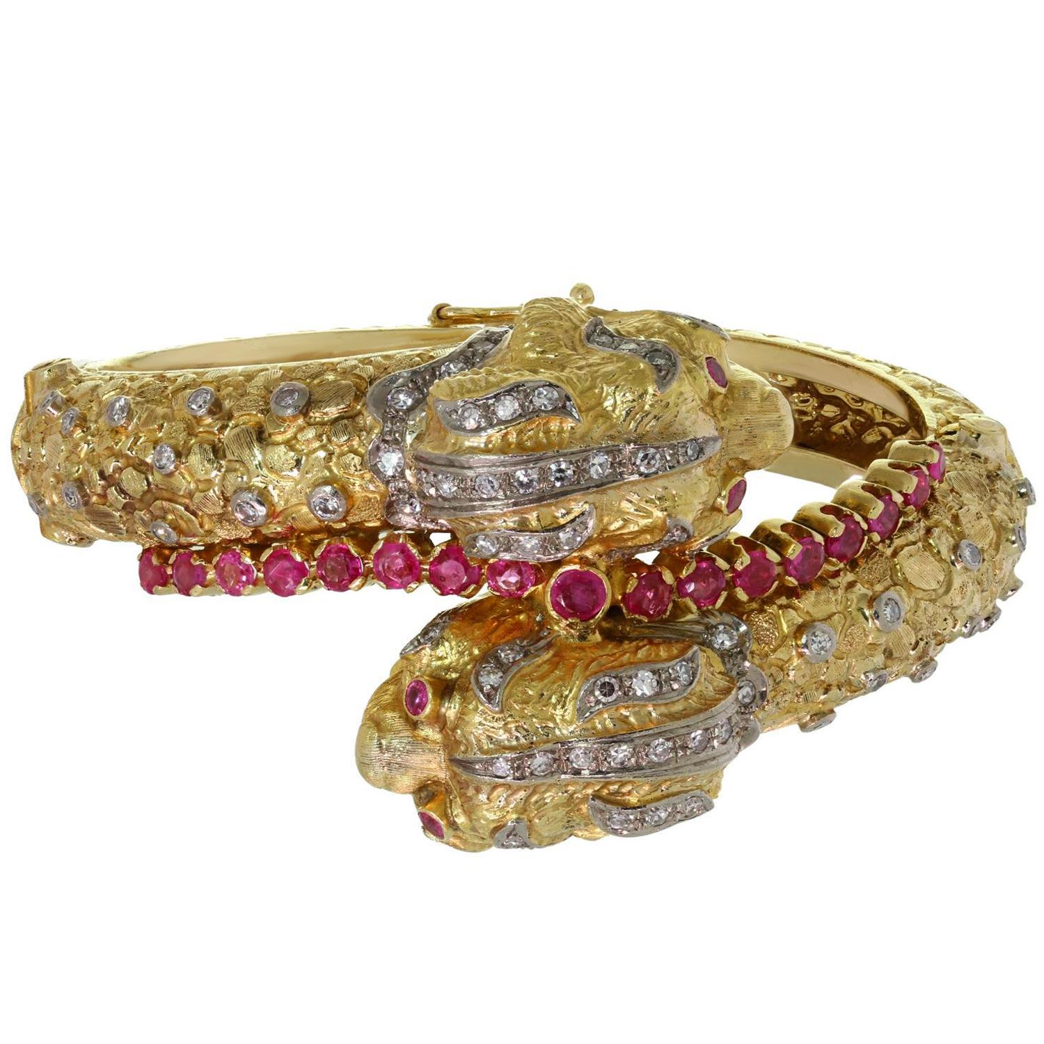 This fabulous Ilias Lalaounis bangle bracelet features a stunning two-headed chimera design crafted in 18k textured yellow gold and set with 21 red rubies weighing an estimated 1.90 carats and 74 round diamonds weighing an estimated 0.90 carats.