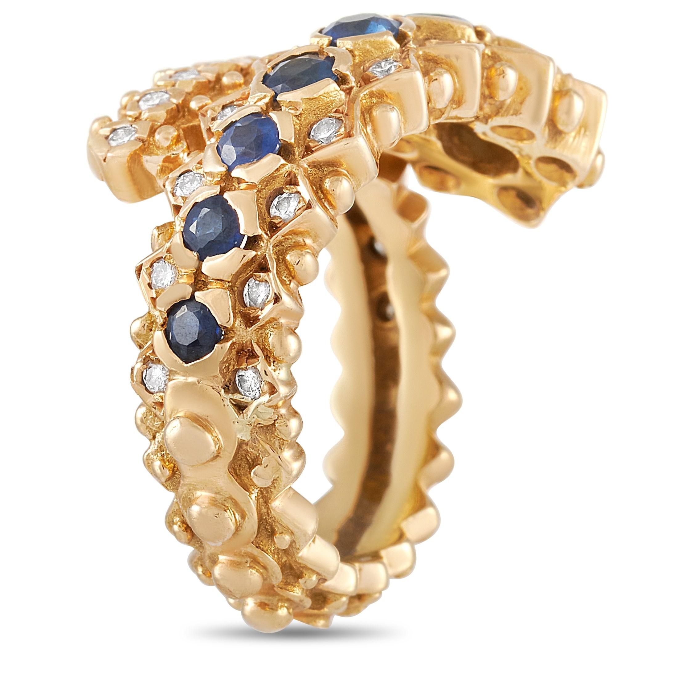 This Ilias Lalaounis 18K Yellow Gold Diamond and Sapphire Ring is a dramatic statement piece made with 18K yellow gold that wraps around the finger. The band is set with round-cut diamond and sapphires around the ring. The ring has a band thickness