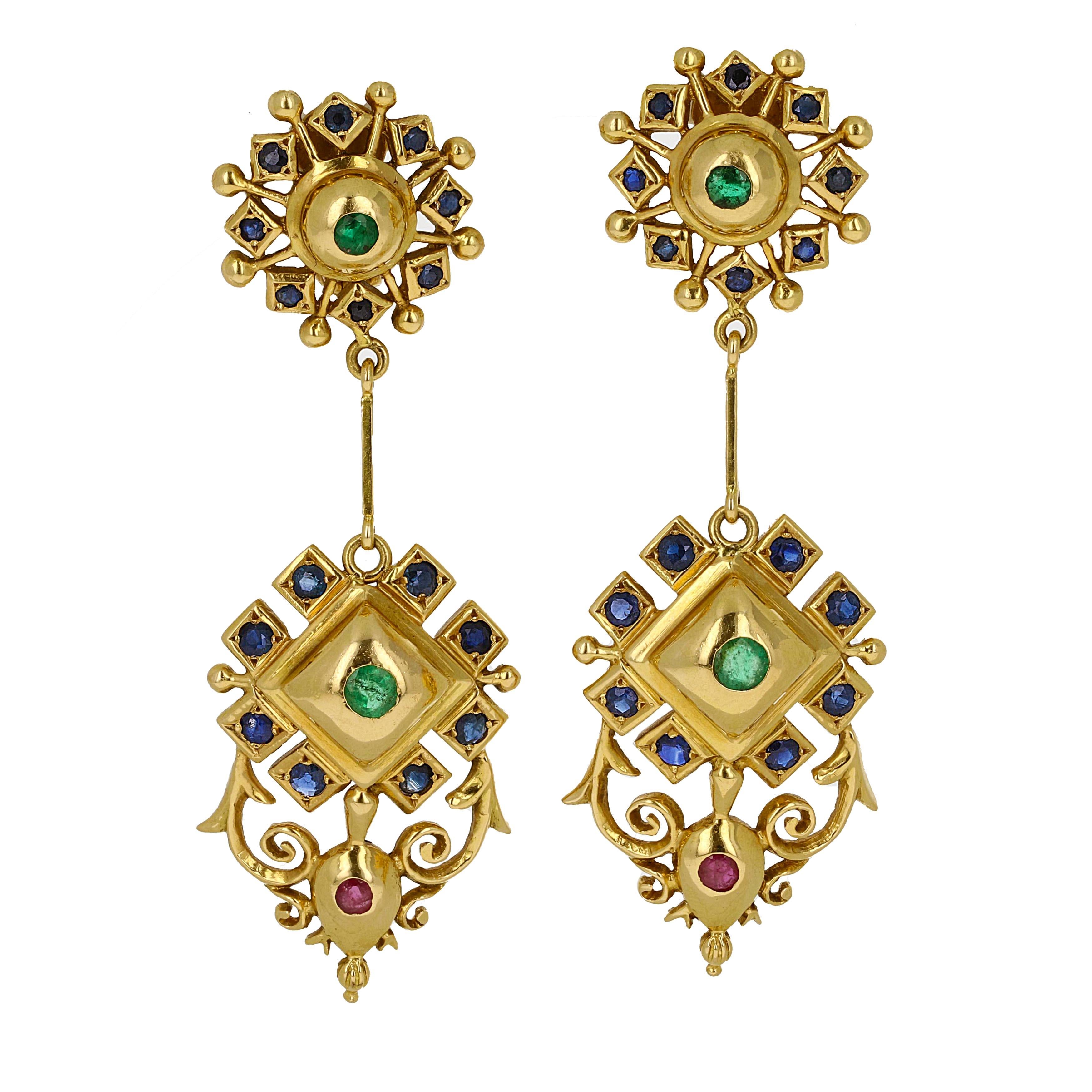Ilias Lalaounis 18kt yellow gold 1970's retro drop chandelier gemstone earrings. These yellow gold earrings have a total of 2 rubies, 4 emeralds and 32 cabochon cut sapphires. Each stone is bezel set and embraced with intricate hand filigree.

They