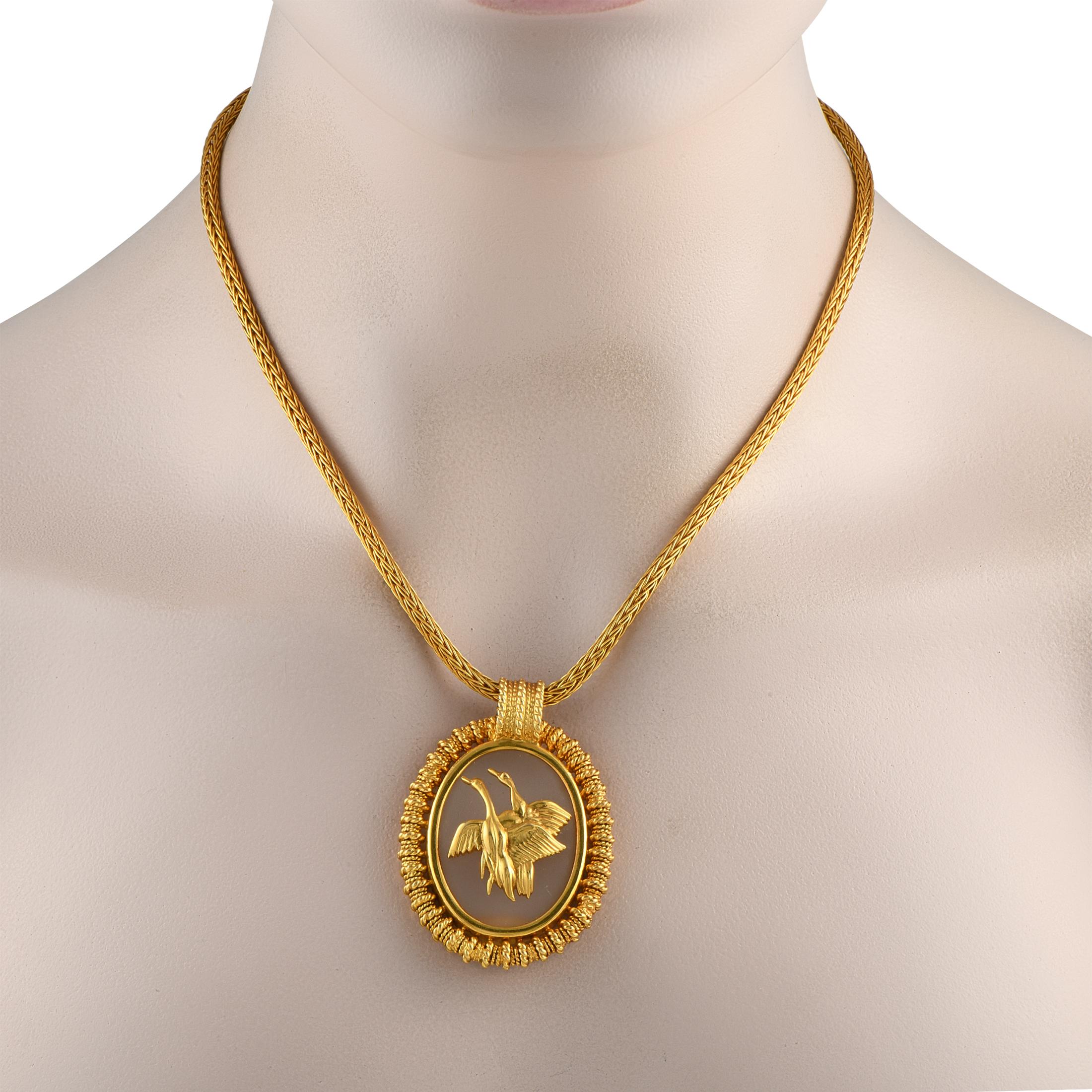 A work of art by Greek jeweler Ilias Lalaounis. This necklace's imposing presence is characterized by a thick, weighty necklace measuring 16 inches long. It holds a 2 by 1.5 oval, medallion-like pendant composed of a rock crystal and a textured,