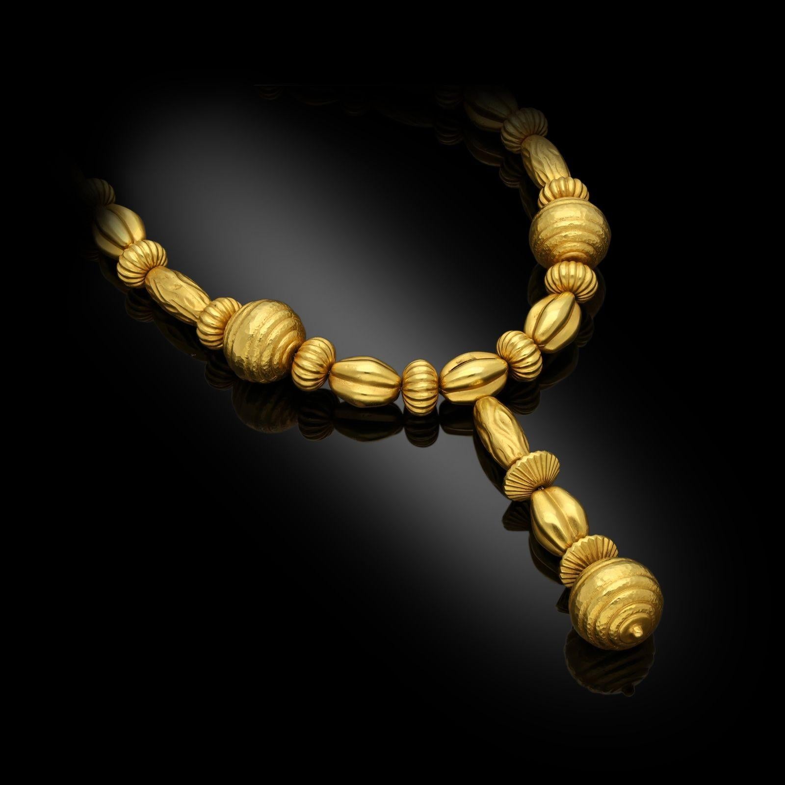 A stylish gold bead necklace by Lalaounis, c.1960s, the necklace from the Minoan and Mycenaean collection, designed as a row of alternating fluted or textured barrel shape beads with ribbed bouton shape beads all in 18ct yellow gold and with a