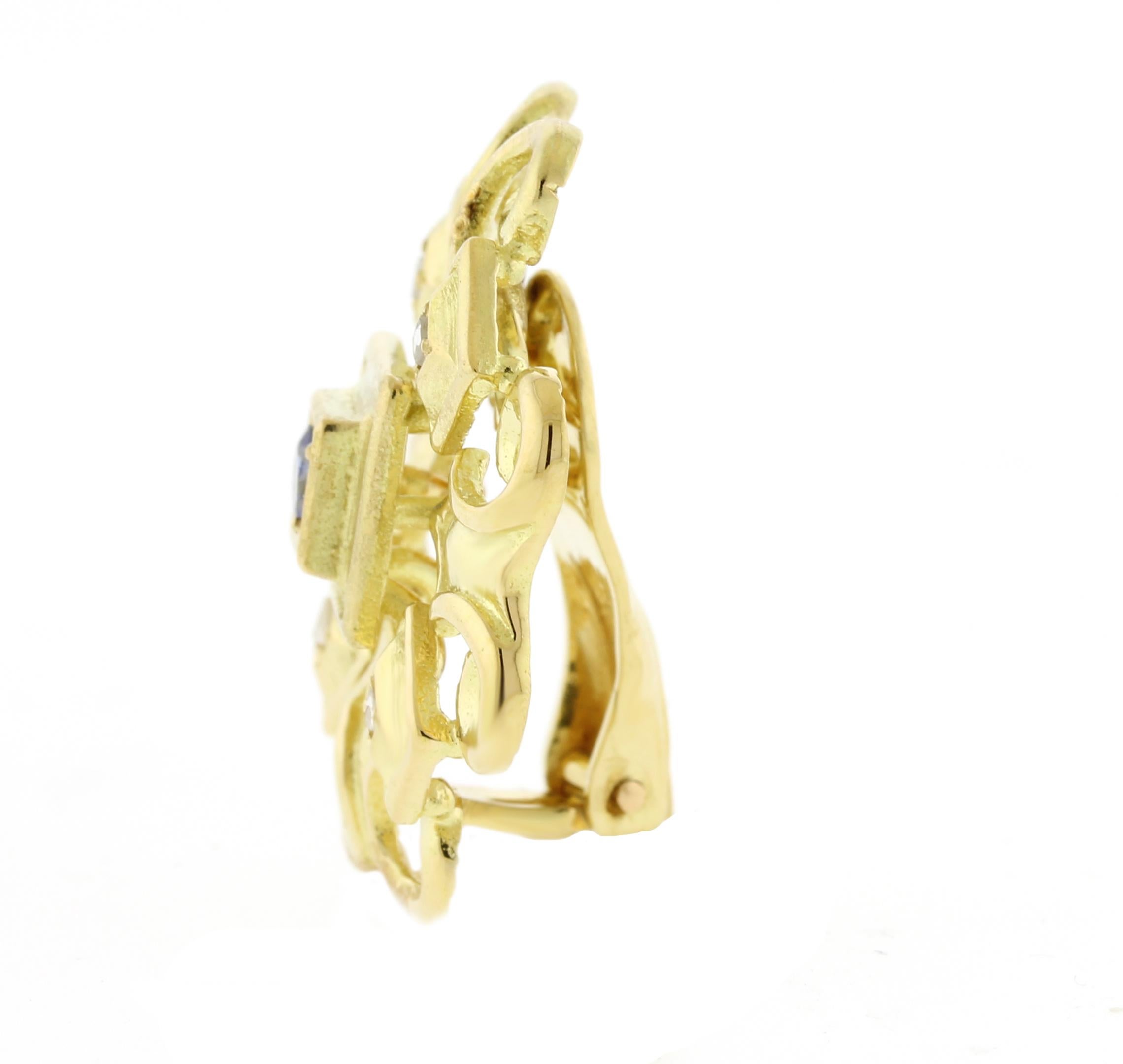 Ein prächtiges Paar geometrischer Ohrringe von Lalaounis, die fachmännisch aus 18 Karat Gold gefertigt sind. Diese auffälligen Ohrringe, die jeweils 1 1/8 Zoll im Quadrat messen, weisen zwei atemberaubende Saphire mit einem Gesamtgewicht von 0,30