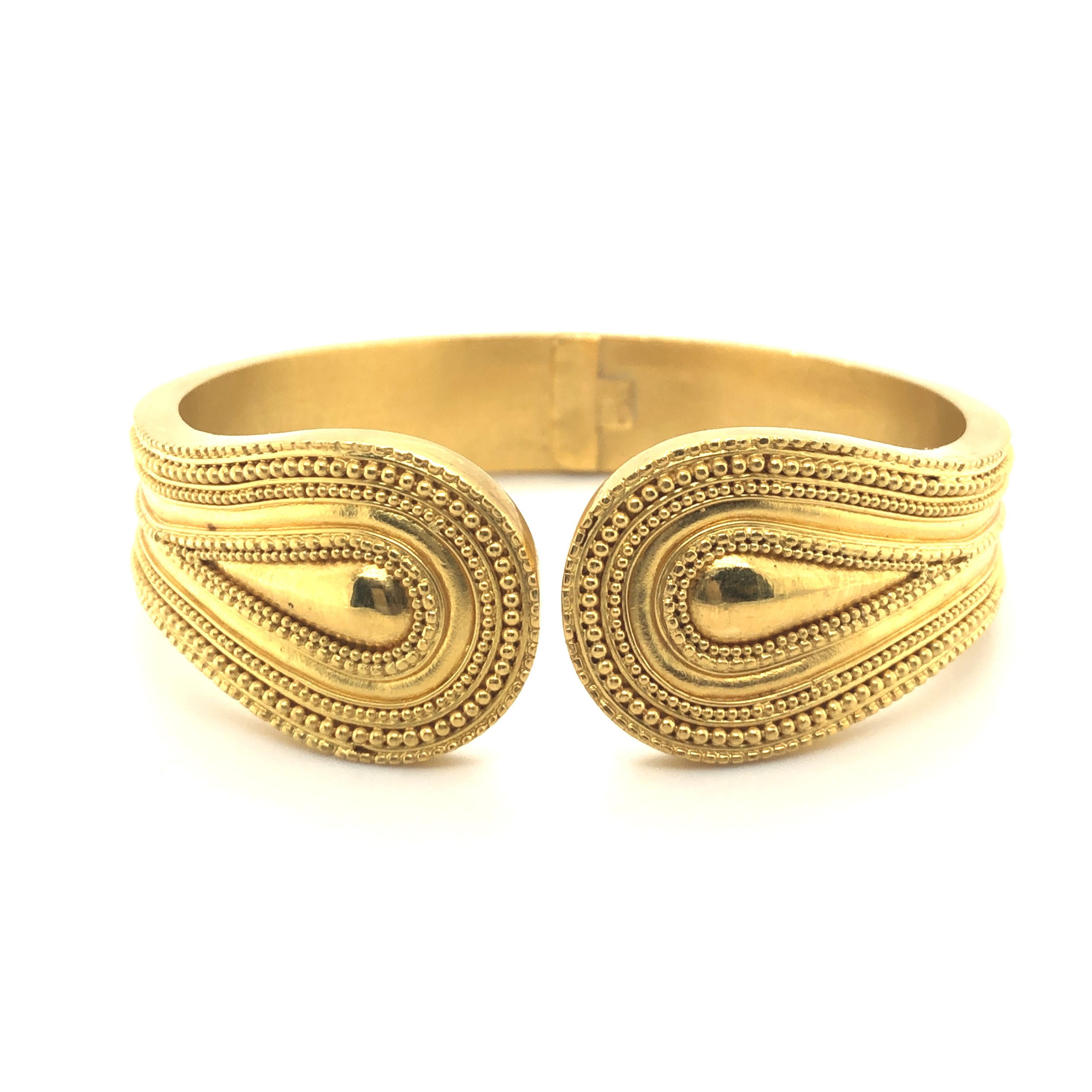 This classic cuff bracelet by Greek designer Ilias Lalaounis is crafted in 18 karat yellow gold and is accented by beaded and curved lines. The bangle is hollow and the terminals als elegantly widened.

Very chic and comfortable to wear.

Maker's