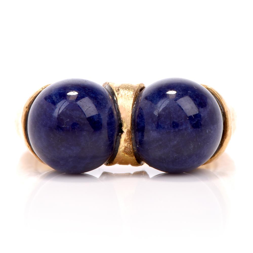 This gorgeous vintage Hellenistic style lapis lazuli ring is hand crafted in 18-karat yellow gold. Exposing two bezel-set lapis lazuli drops measuring approx. 9mm. The gold on this ring shows an exquisite hammered technique. Ring weighs 11.2 grams,